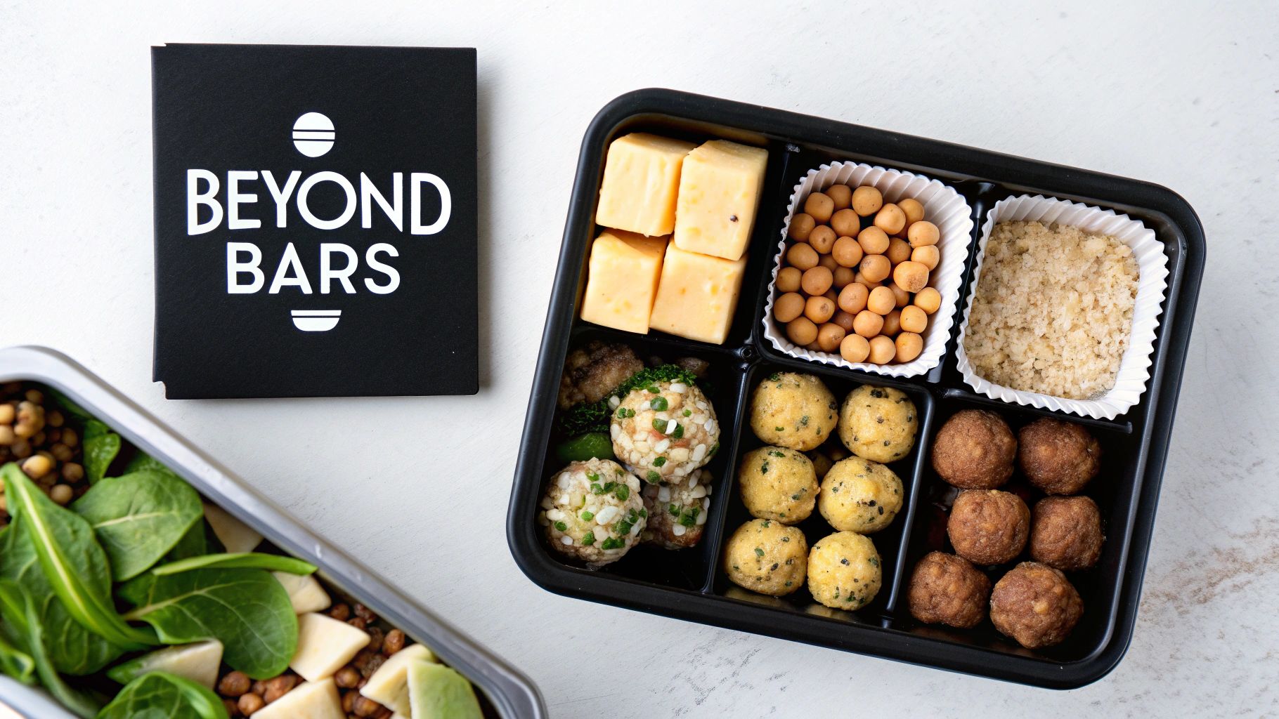 Assortment of grab-and-go protein snacks in a bento box, with a 'Beyond Bars' brand box.