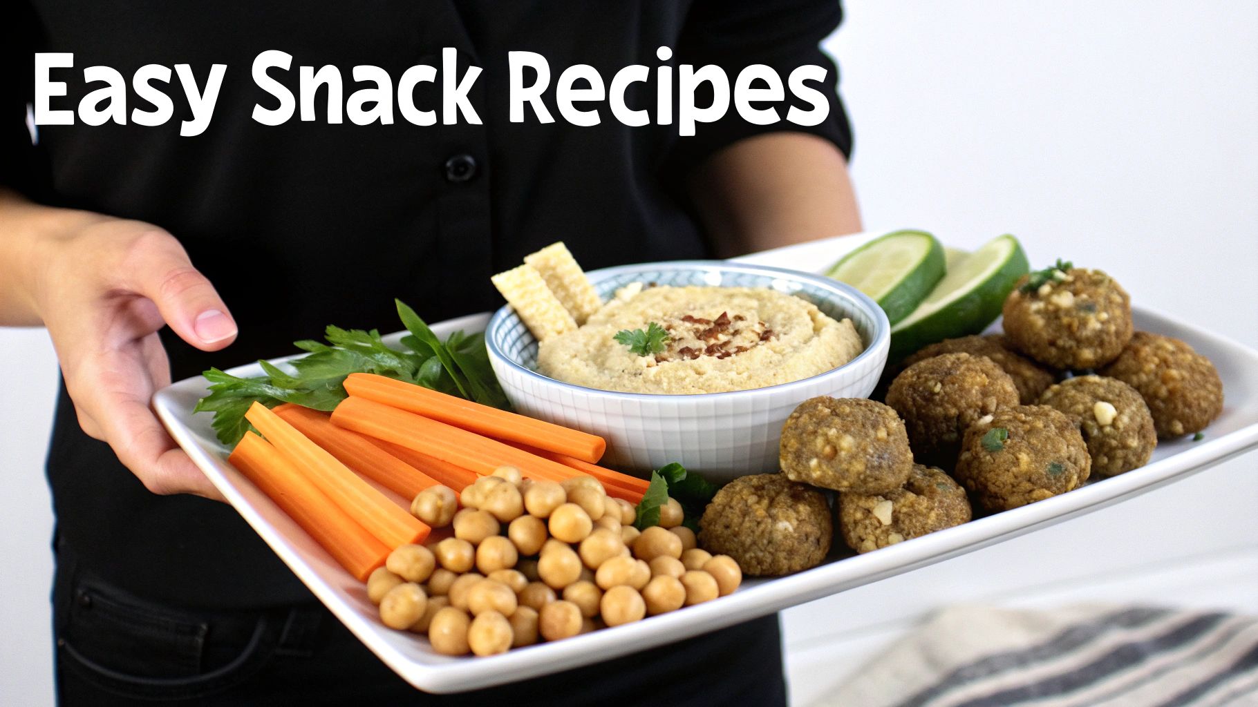 A person holds a white tray filled with healthy vegan snacks: hummus, carrots, chickpeas, and falafel, with text 'Easy Snack Recipes'.