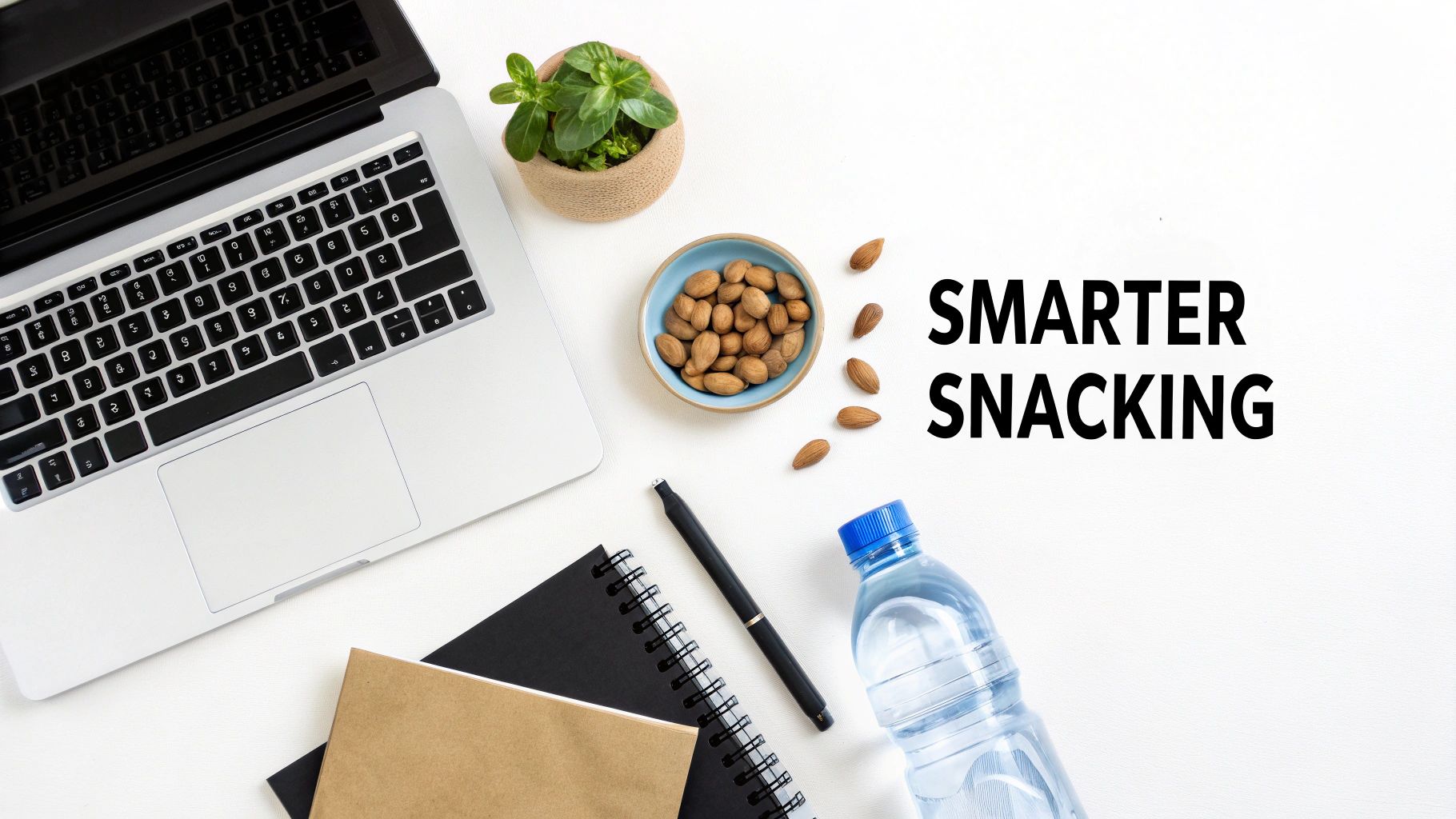 Overhead view of a laptop, plant, and almonds, emphasizing smarter snacking at a desk.