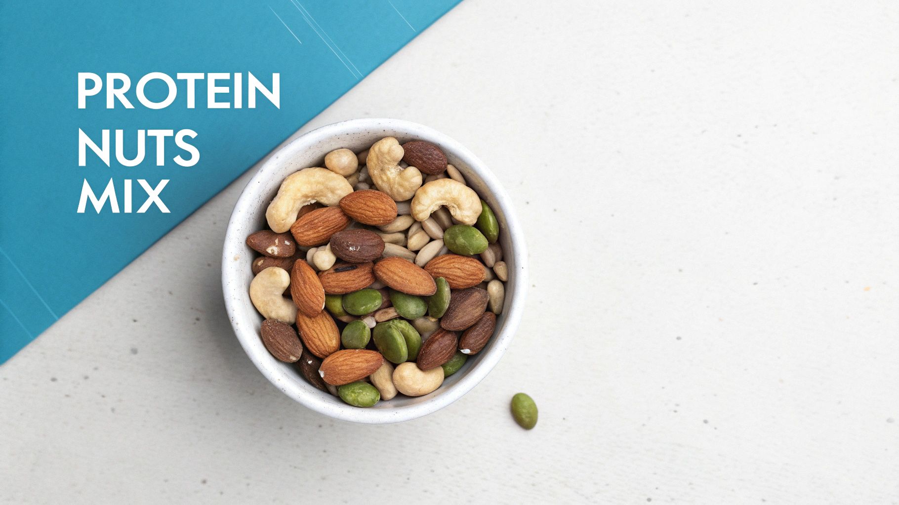 A white bowl of protein nuts mix, including almonds, cashews, and pistachios, on a light counter.