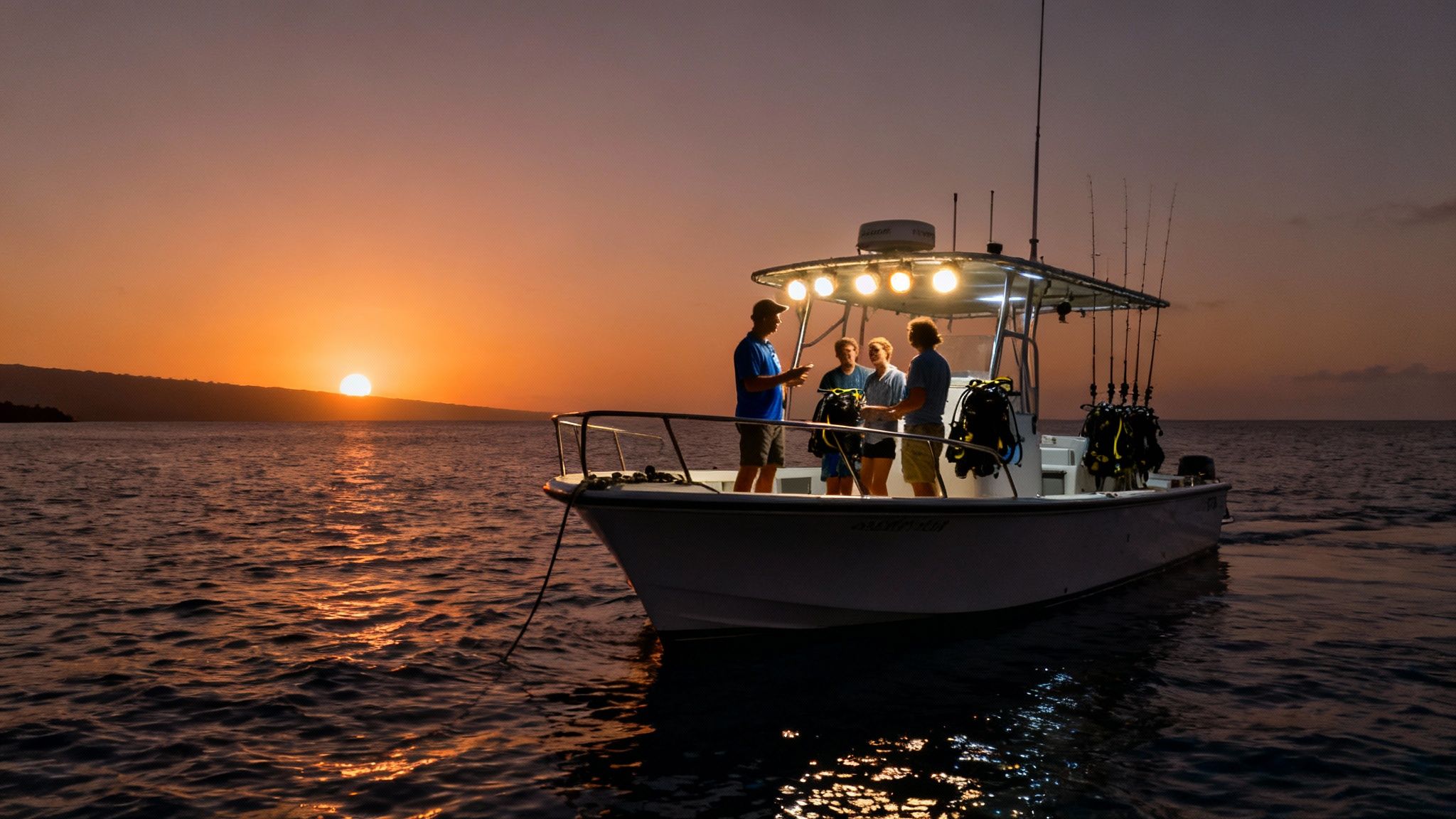 Scuba divers in a semi-circle on the ocean floor watching a manta ray swim overhead