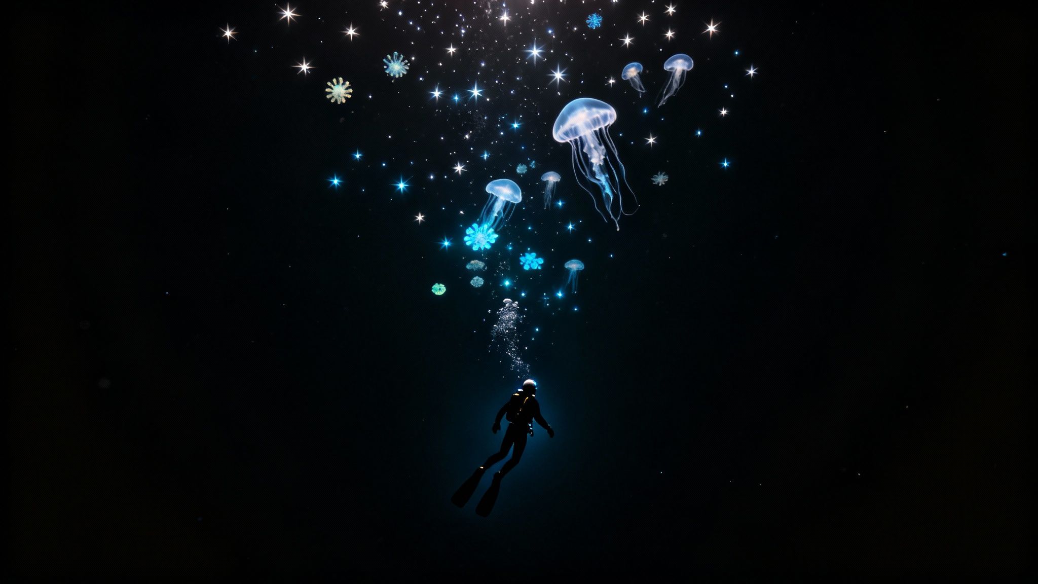 A scuba diver swims upwards in the dark ocean towards glowing jellyfish and sparkling light.