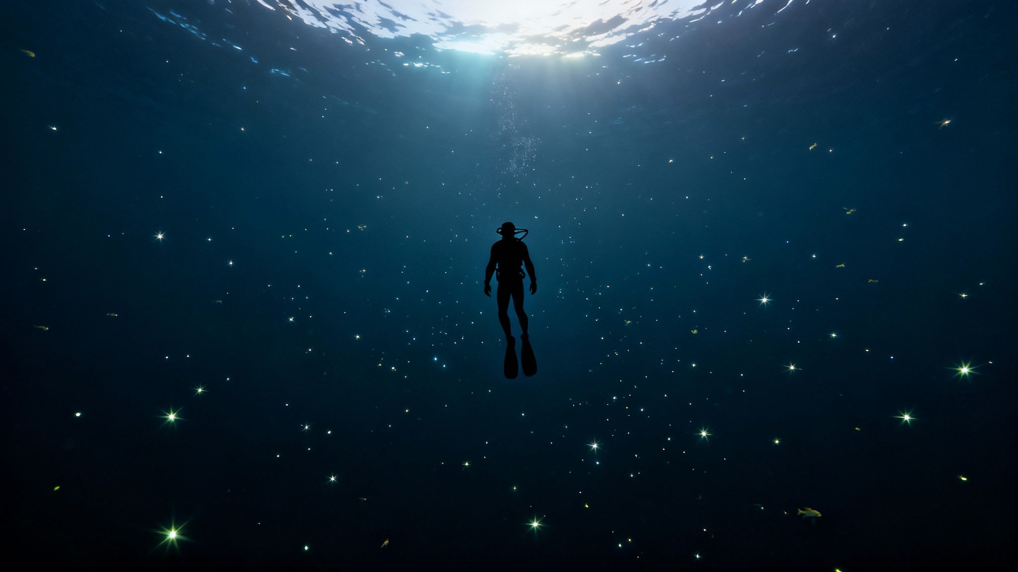 A lone scuba diver, silhouetted against sunlight, descends into deep blue water filled with sparkling light.