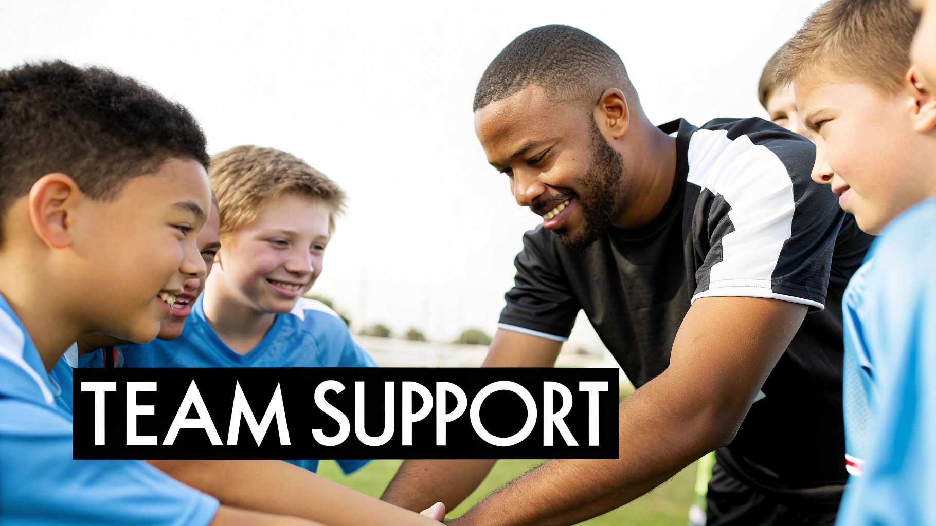 A smiling soccer coach and young players huddle, showing team support and camaraderie.