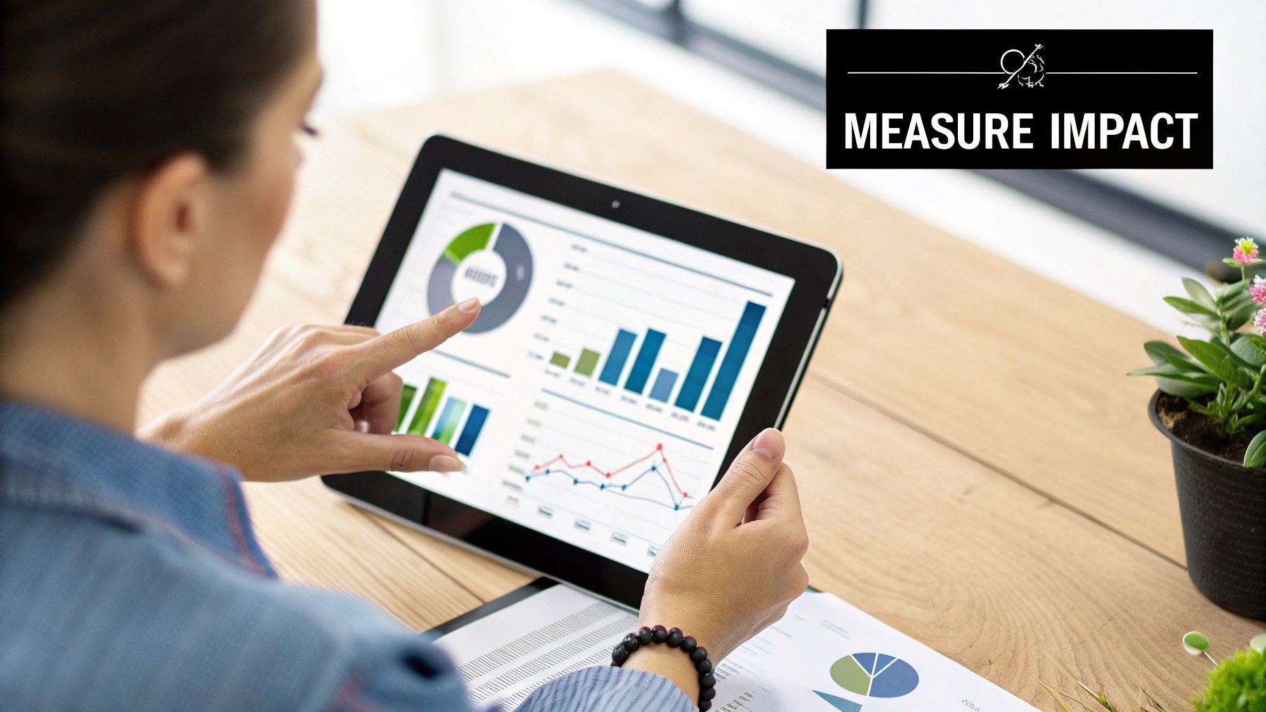 A person analyzes data visualizations on a tablet, focusing on impact measurement.