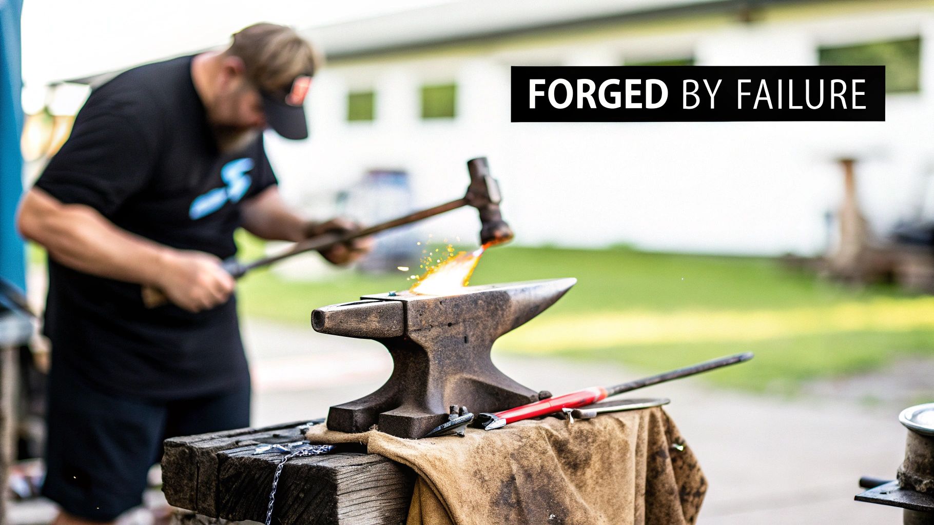 A blacksmith hammers a glowing metal piece on an anvil, creating sparks, with text 'FORGED BY FAILURE'.