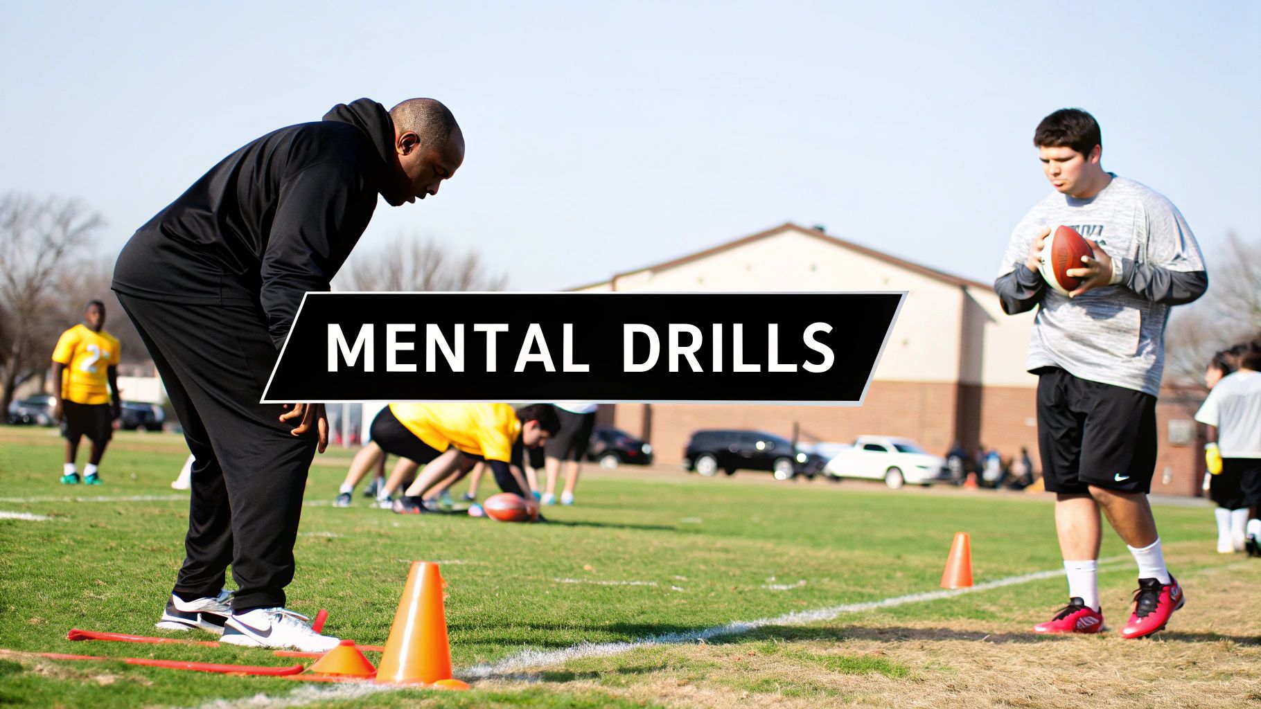 Coach and football players practicing mental drills on a sunny field with cones and a football.
