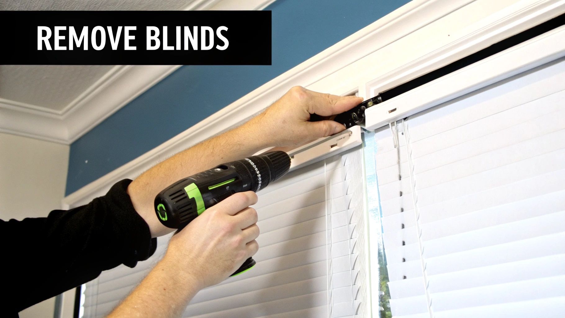 A person using a flathead screwdriver to gently pry open the bracket of a horizontal window blind.
