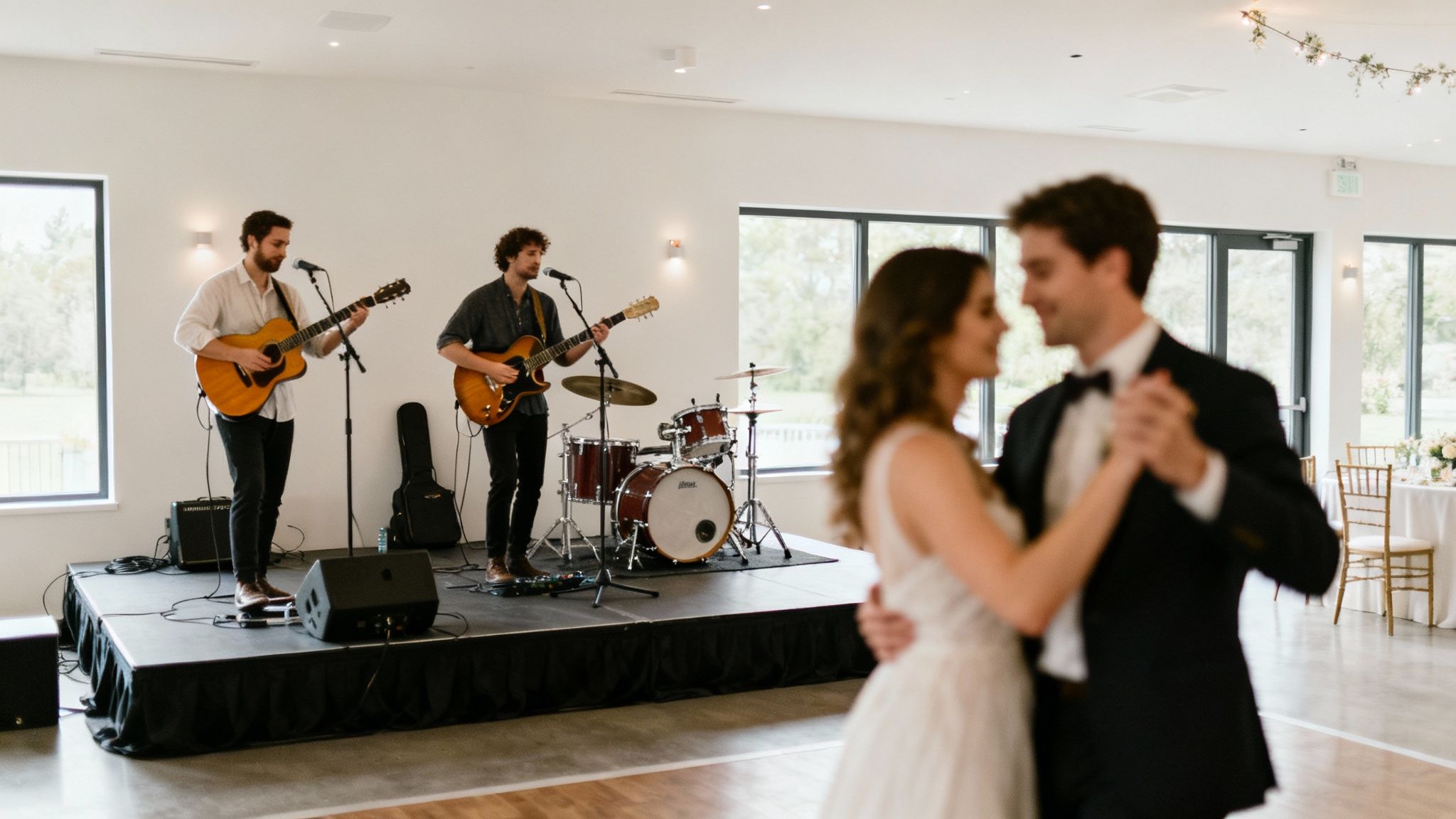 Live band performing at wedding reception while bride and groom share first dance