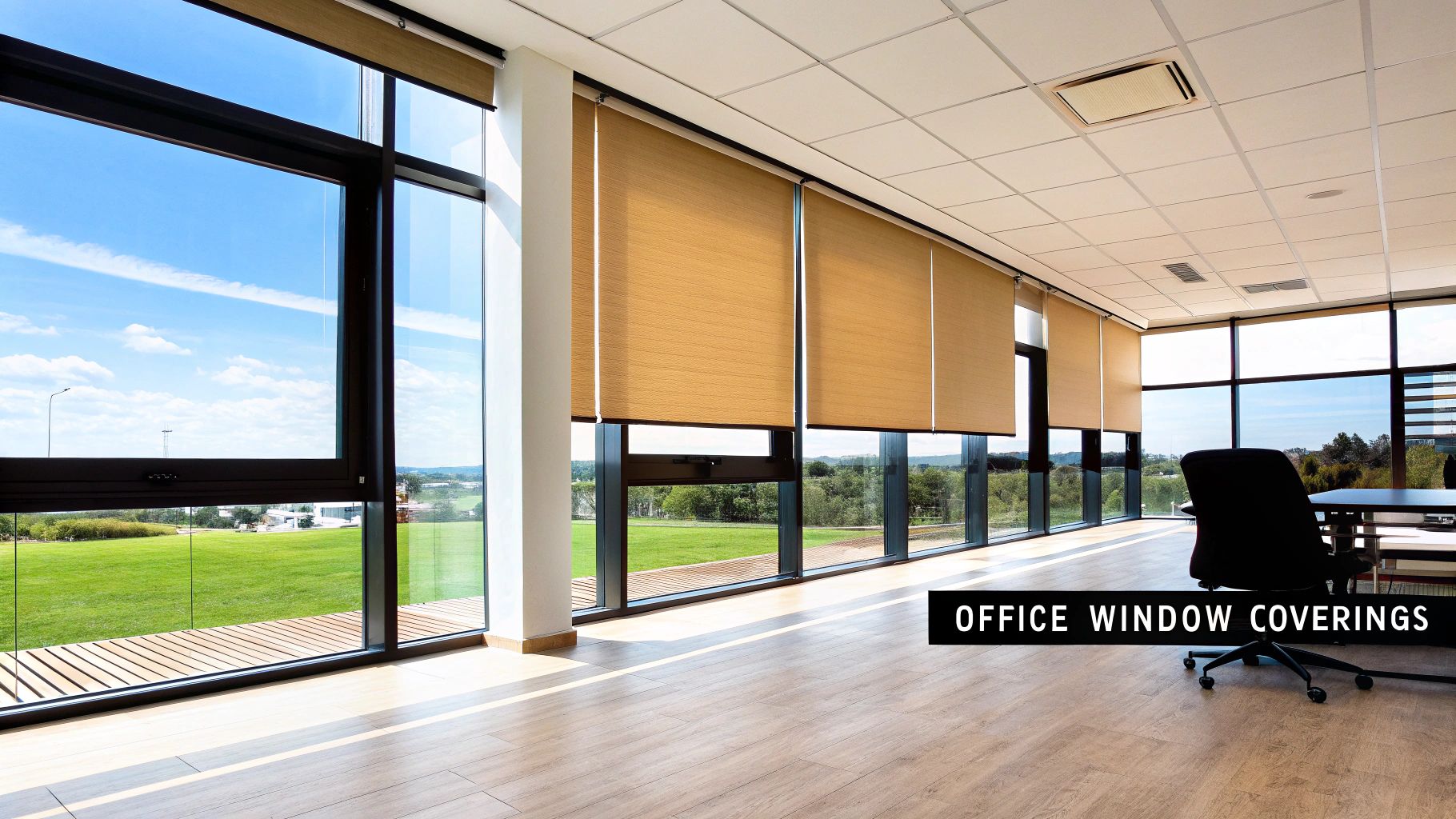 Modern office with large windows featuring light brown roller blinds and a scenic outdoor view.