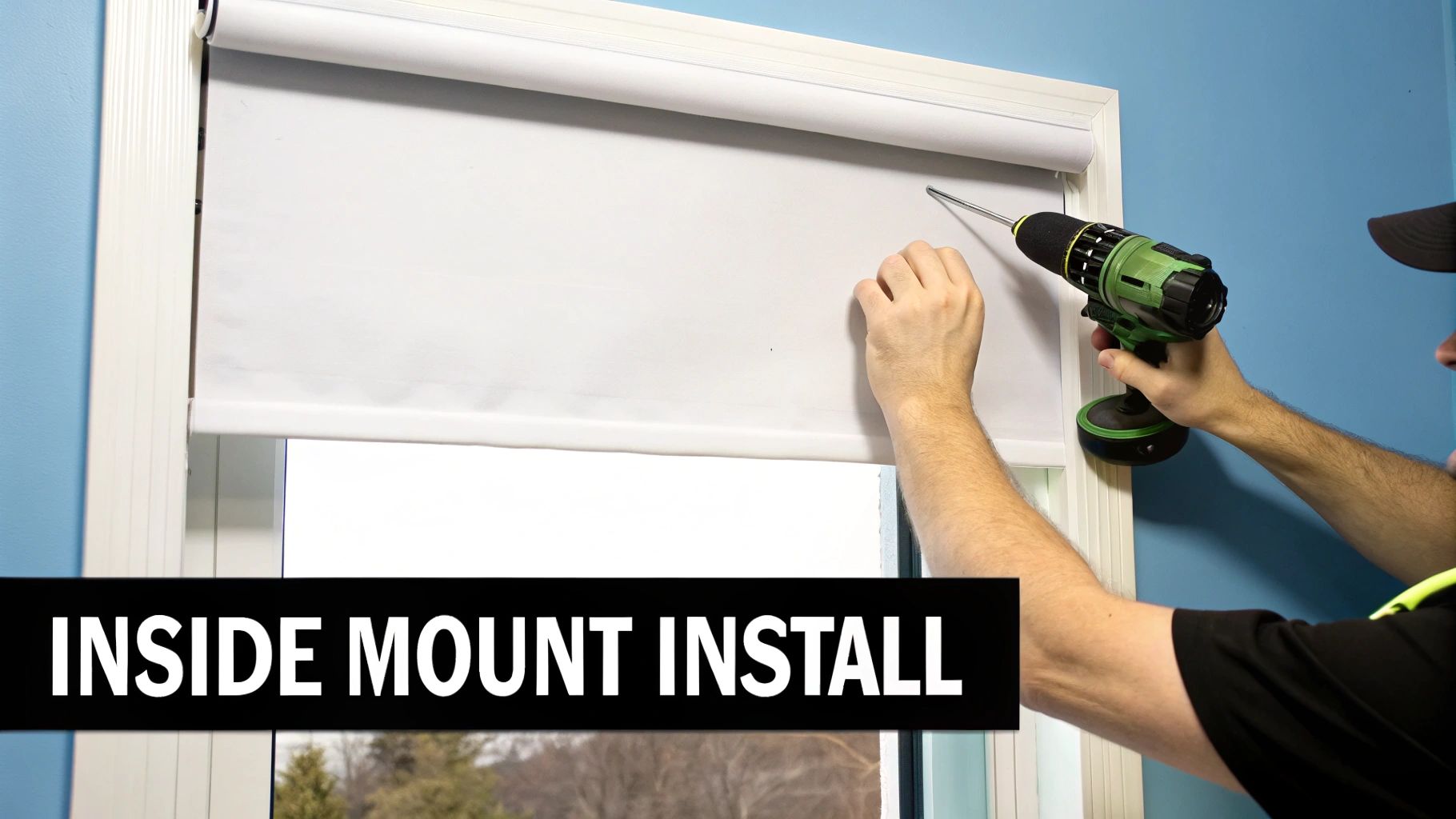A person uses a power drill to install a white roller shade inside a window frame, labeled as an inside mount install.