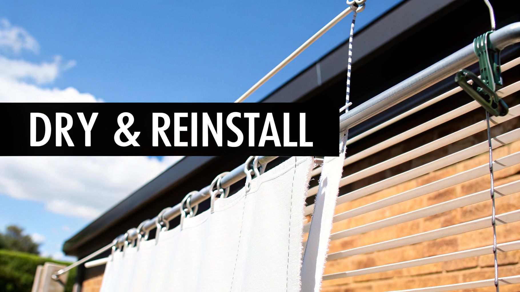 White fabric from venetian blinds drying outdoors on a clothesline under a blue sky, ready for reinstallation.
