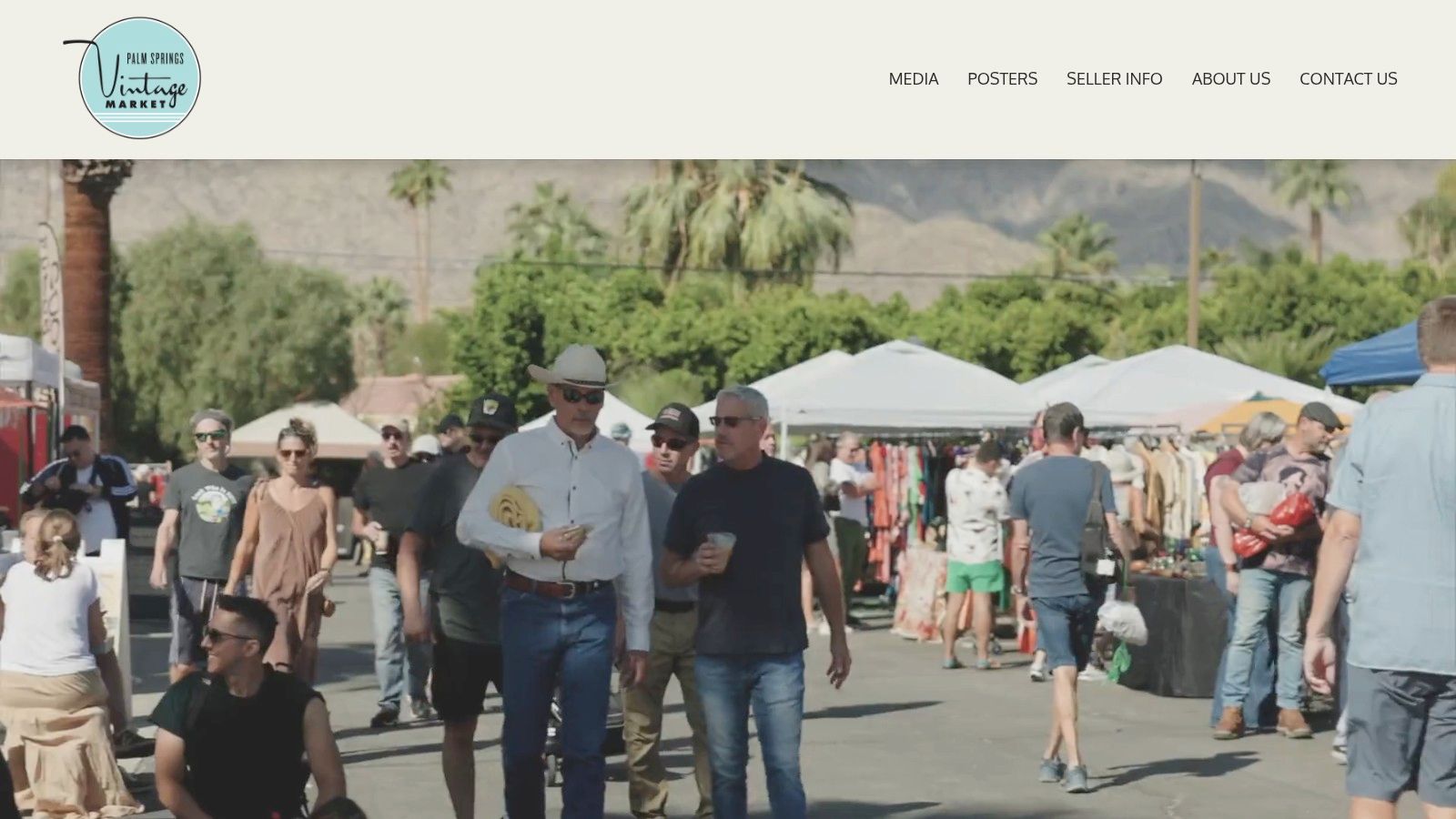 A busy outdoor aisle at the Palm Springs Vintage Market, with shoppers browsing various stalls.