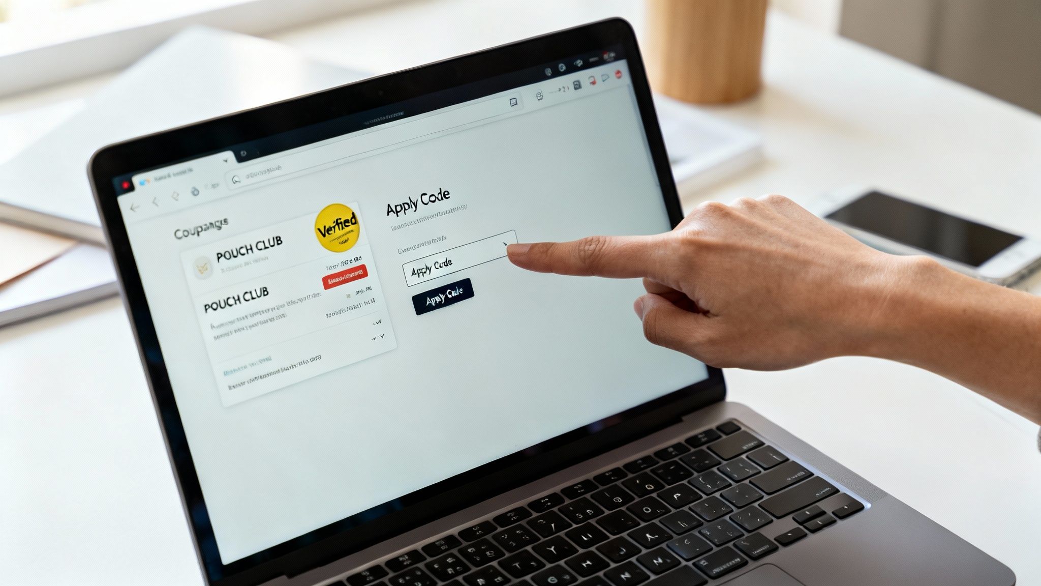 A hand points at a laptop screen displaying a website for applying discount codes.
