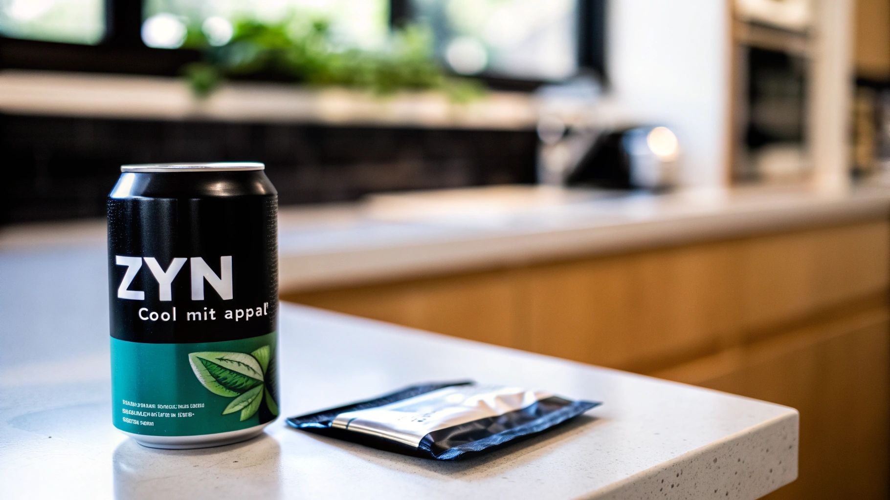 A ZYN "Cool mit appal" beverage can and a small pouch sit on a clean kitchen counter.