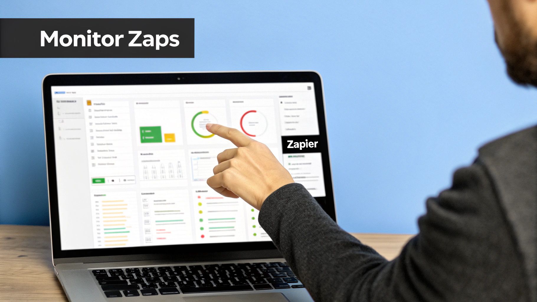 A person's hand points to a laptop screen displaying a Zapier dashboard to monitor Zaps.