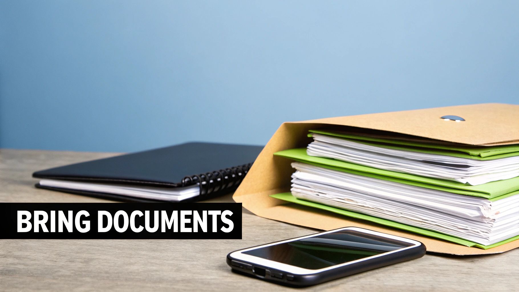 A workspace with a spiral notebook, a file folder full of documents, a smartphone, and a banner reading 'BRING DOCUMENTS'.
