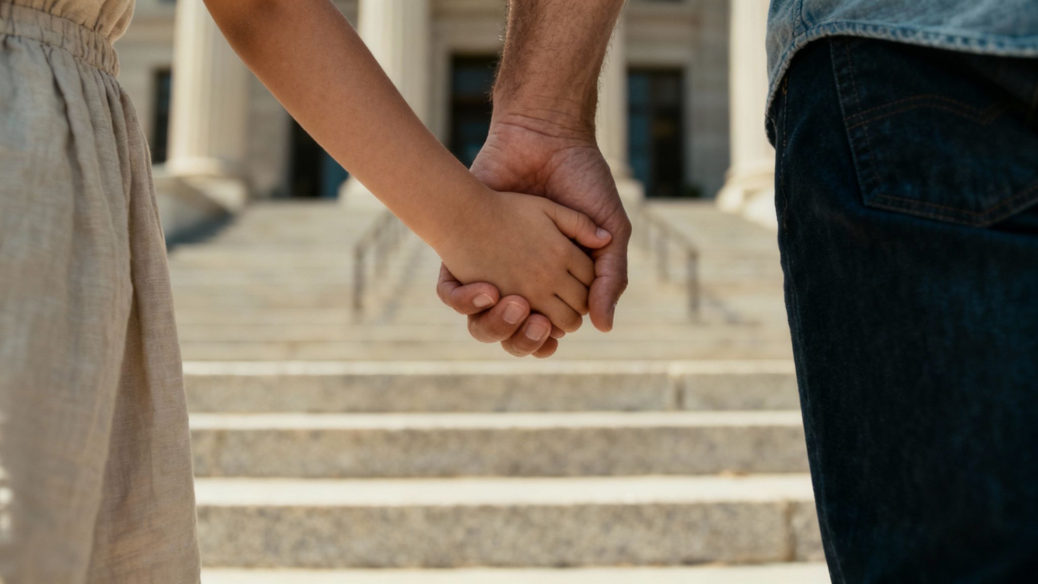 Parent and child holding hands together showing family bond and protective custody relationship
