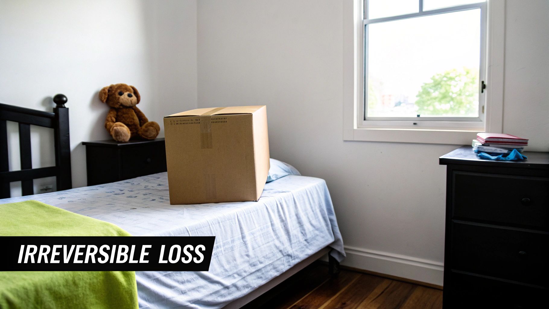 A simple bedroom with a cardboard box on the bed, a teddy bear, and a bright window.