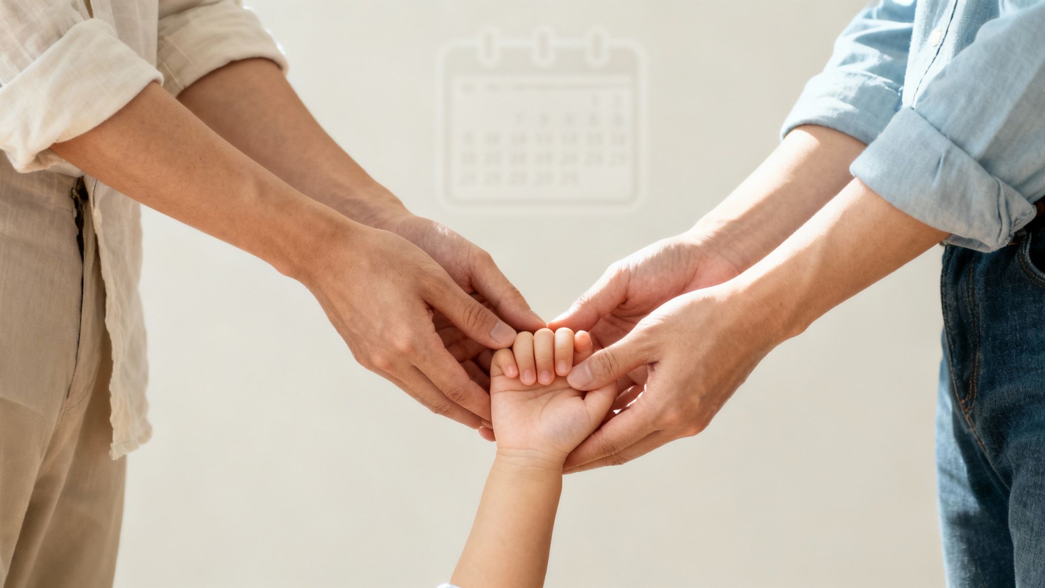 Two adult hands gently holding a child's hand, symbolizing family care and support, with a faint calendar in the background.