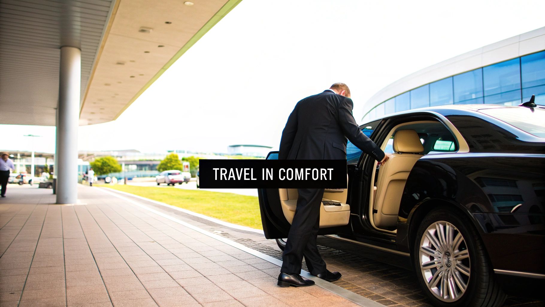A professional chauffeur opening the door of a luxury sedan for a passenger.