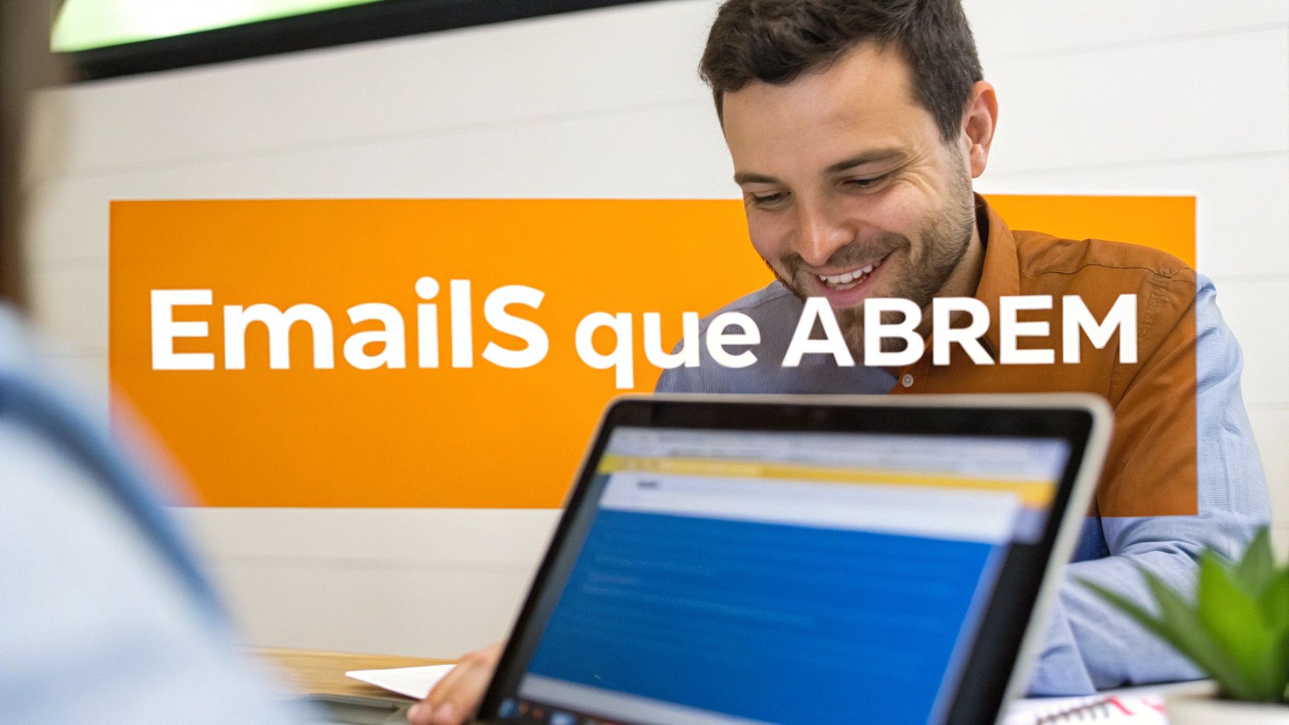 Homem sorrindo em frente a um laptop, com um banner laranja 'Emails que ABREM' visível ao fundo.