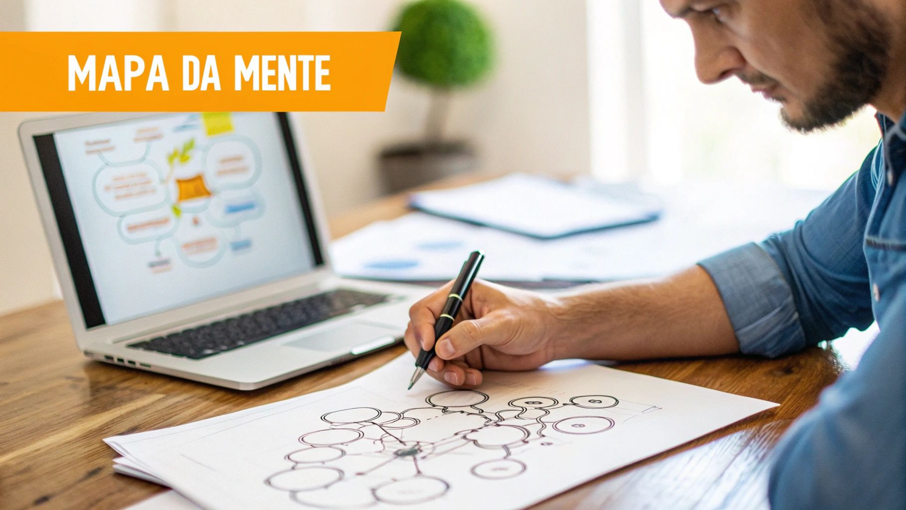 Homem desenhando um mapa mental em papel, com um laptop exibindo outro mapa mental digital. Tema: Mapa da Mente.