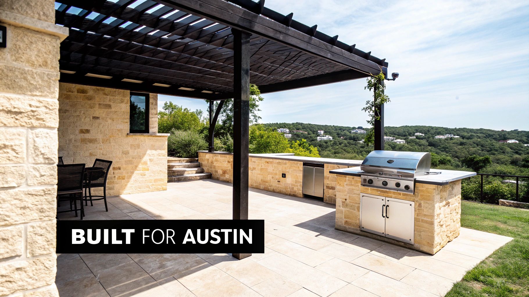 Spacious outdoor kitchen and patio with stone construction, grill, pergola, and scenic hillside view.