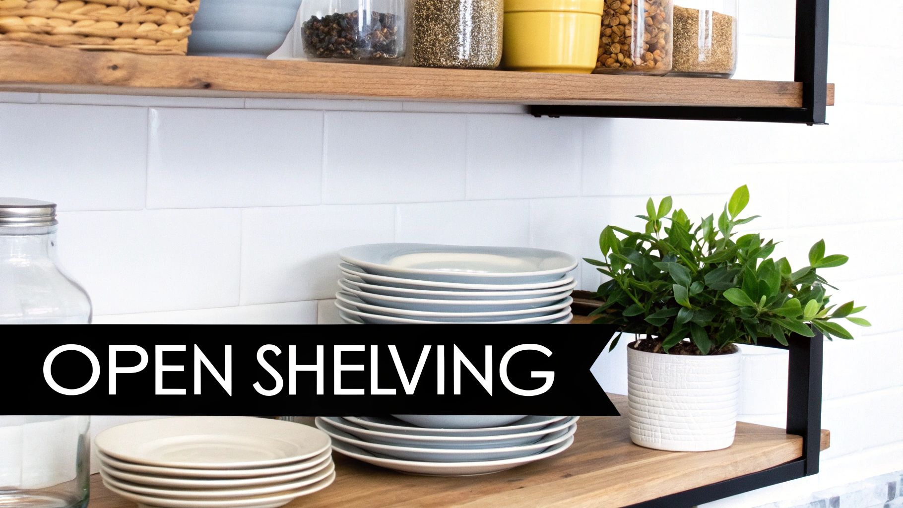 Stylish open kitchen shelving with organized dishes, jars, and a green plant against white subway tile.