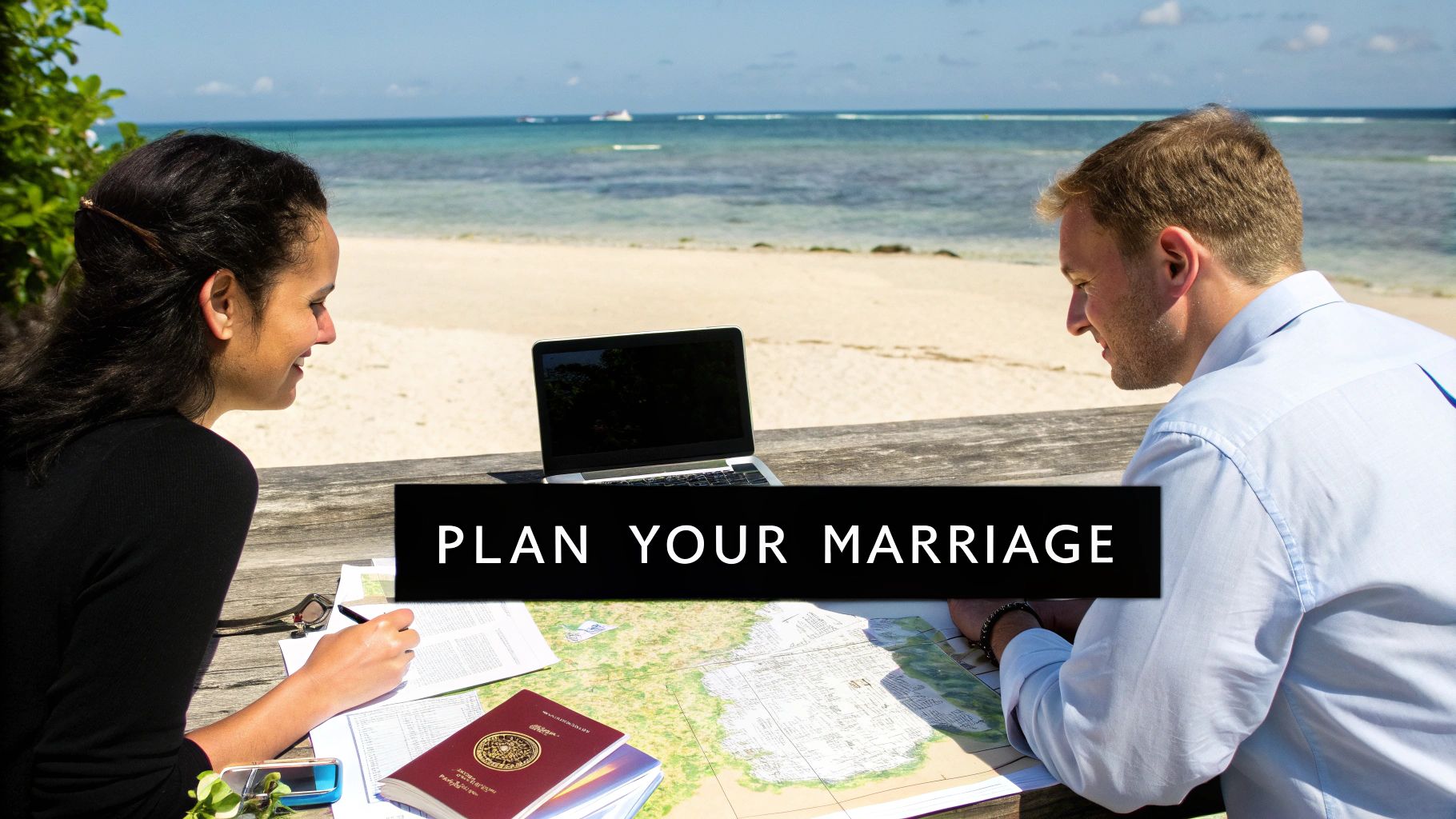 A couple plans their marriage on a beautiful beach, looking at a map and laptop.