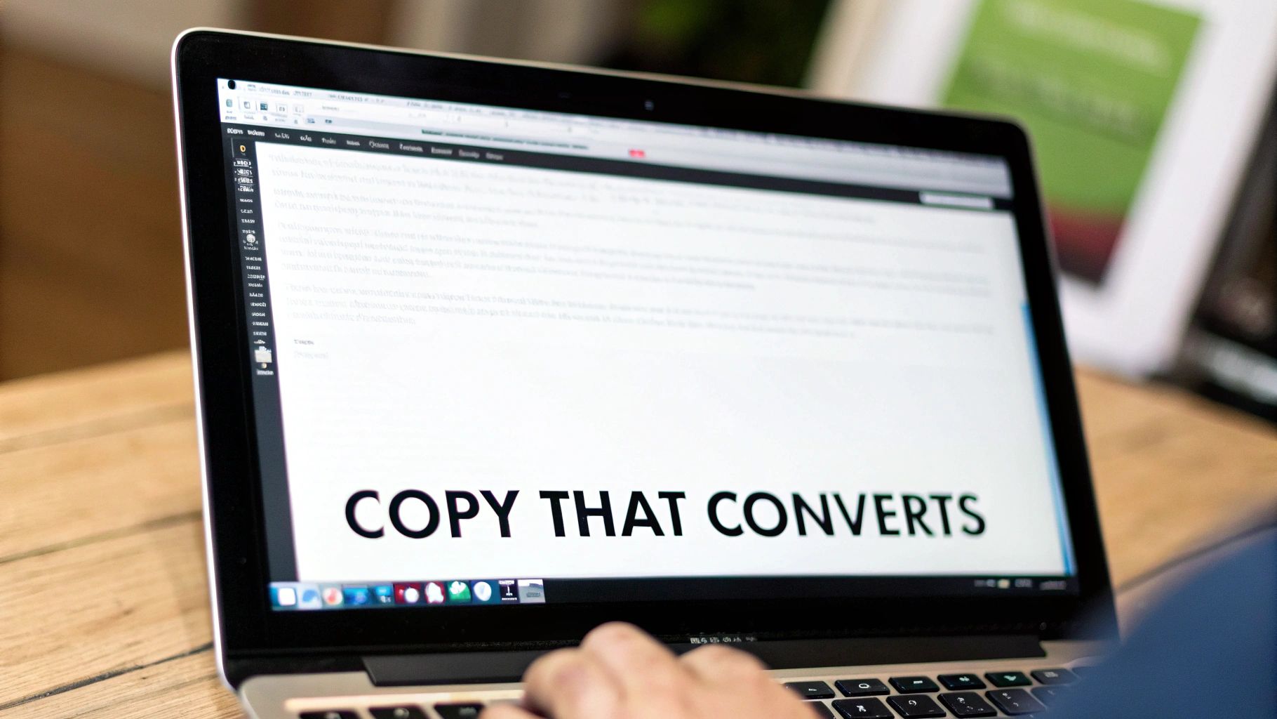 Close-up of a person typing on a laptop screen displaying 'COPY THAT CONVERTS'.