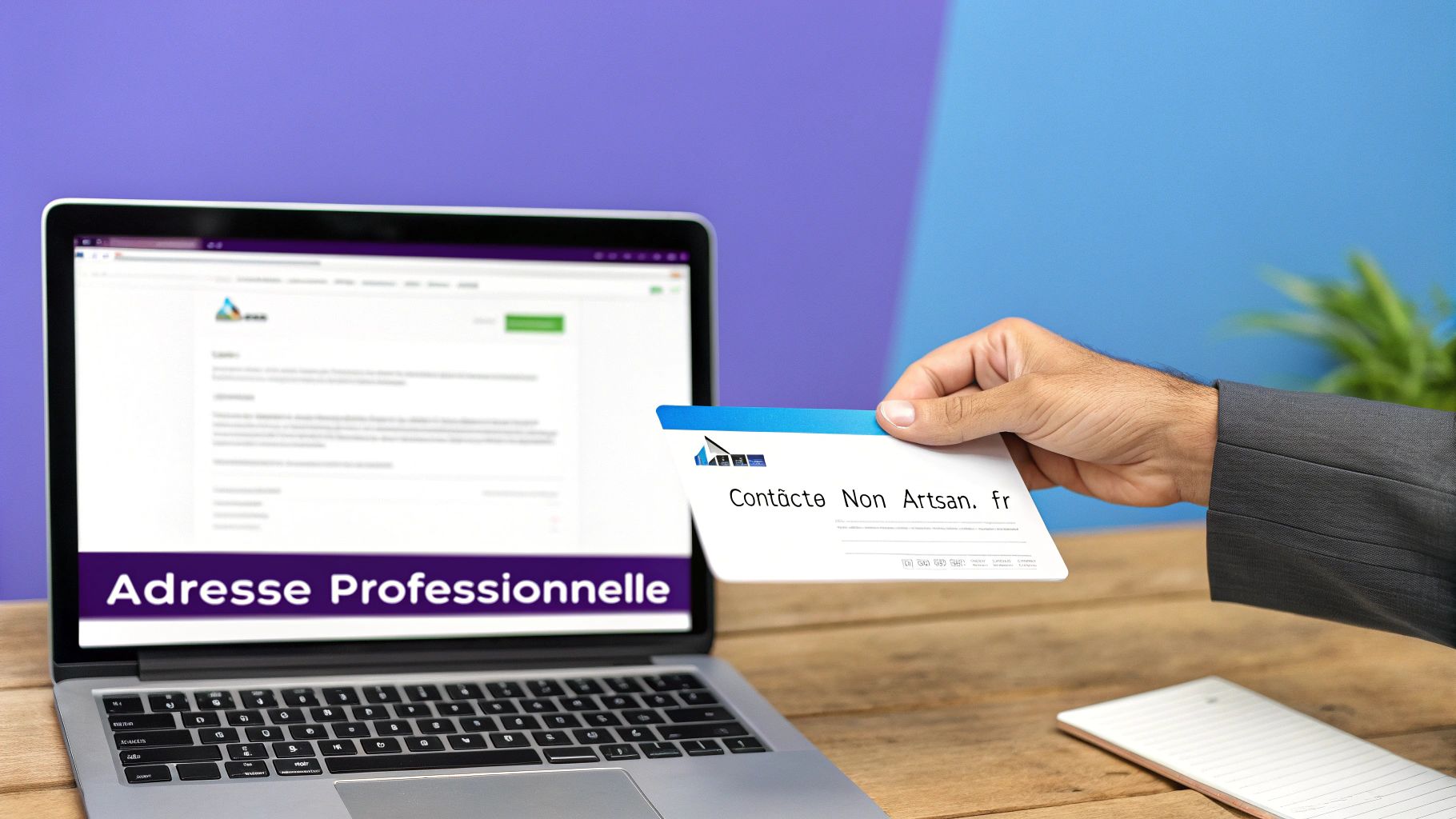 Main tenant une carte de visite devant un ordinateur portable affichant une page web pour une adresse professionnelle.