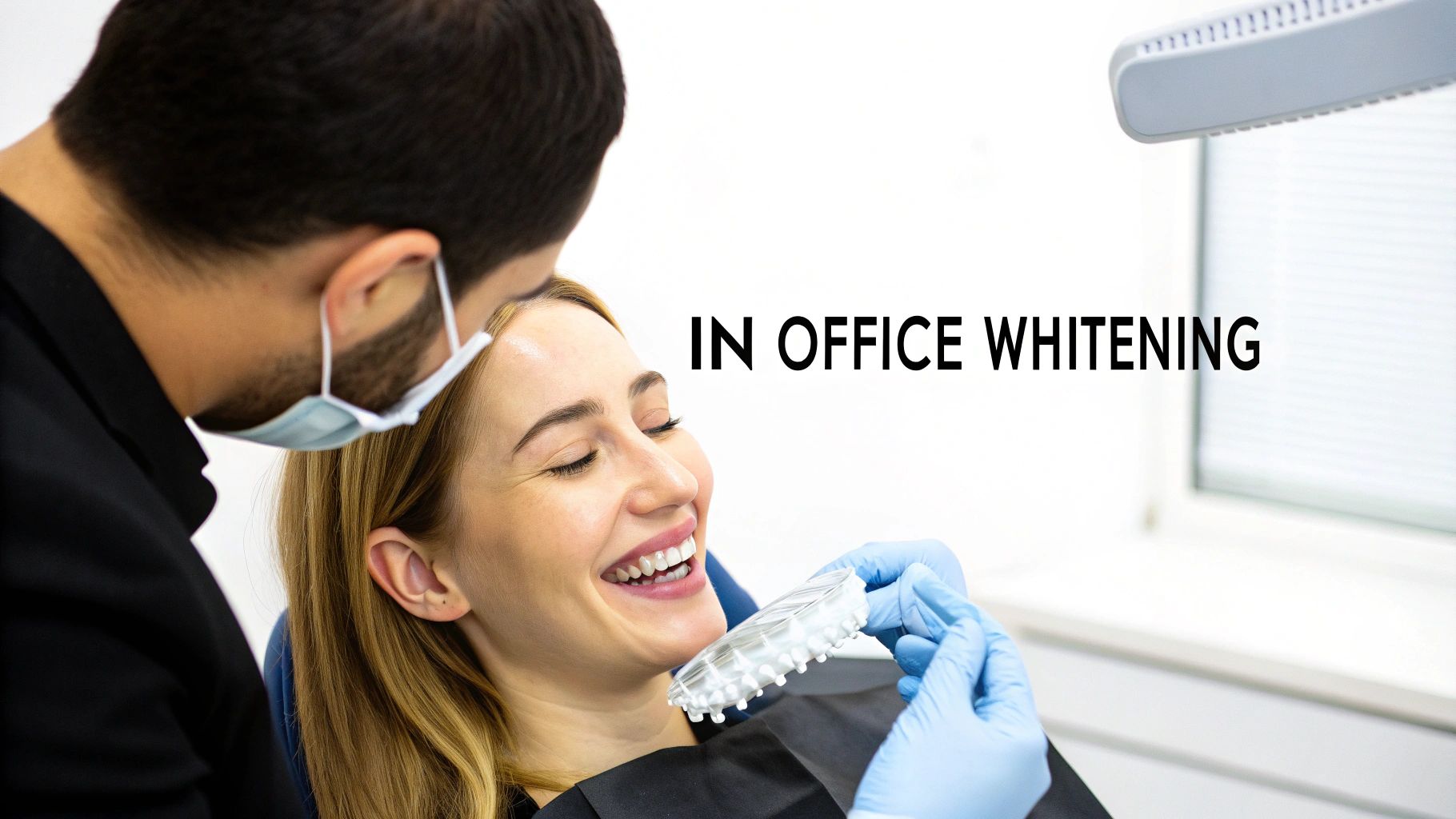 Happy patient comparing teeth shades with a dentist during an in-office whitening procedure.