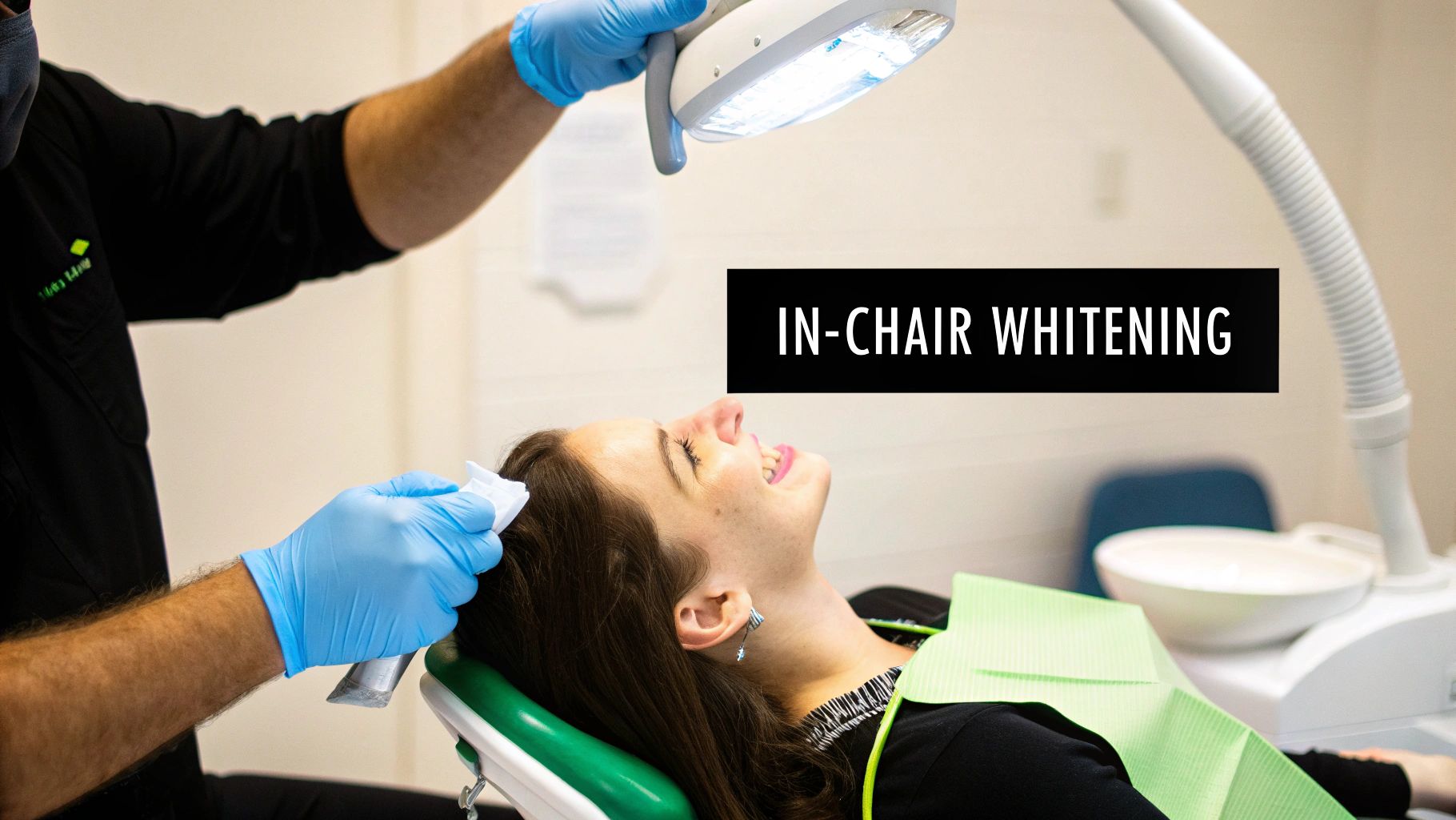 A dental professional performs in-chair teeth whitening on a smiling female patient in a bright dental office.