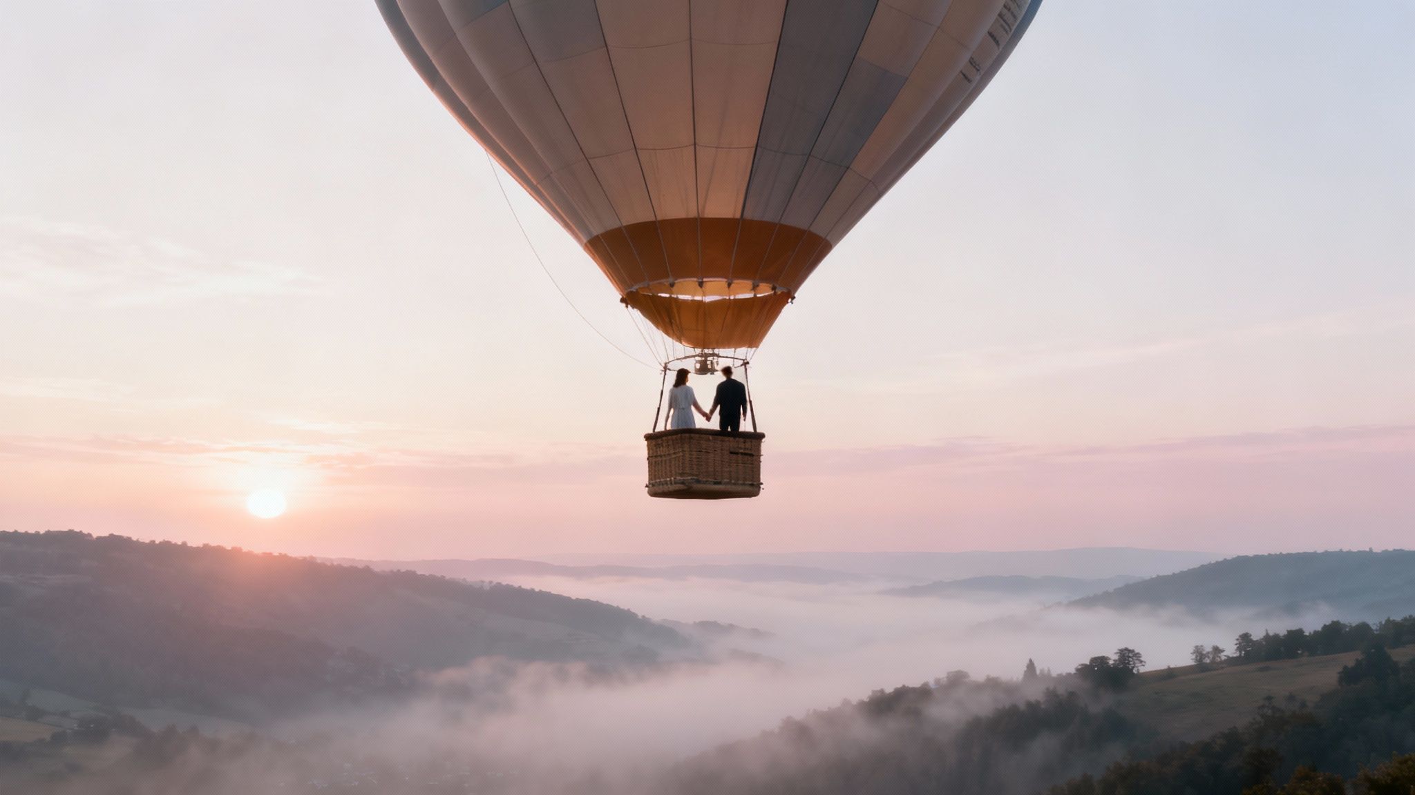 Couple holding hands in hot air balloon basket floating above misty valley at sunrise