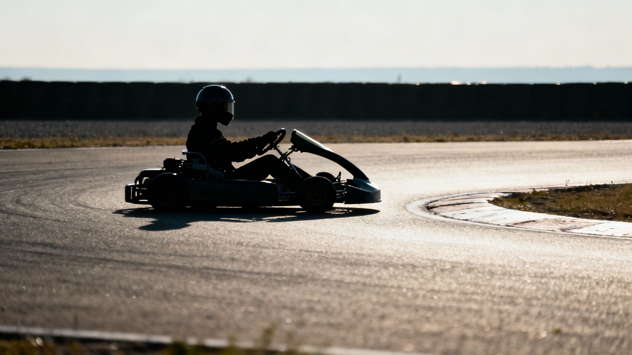 A go-karter leans into a turn to manage weight distribution