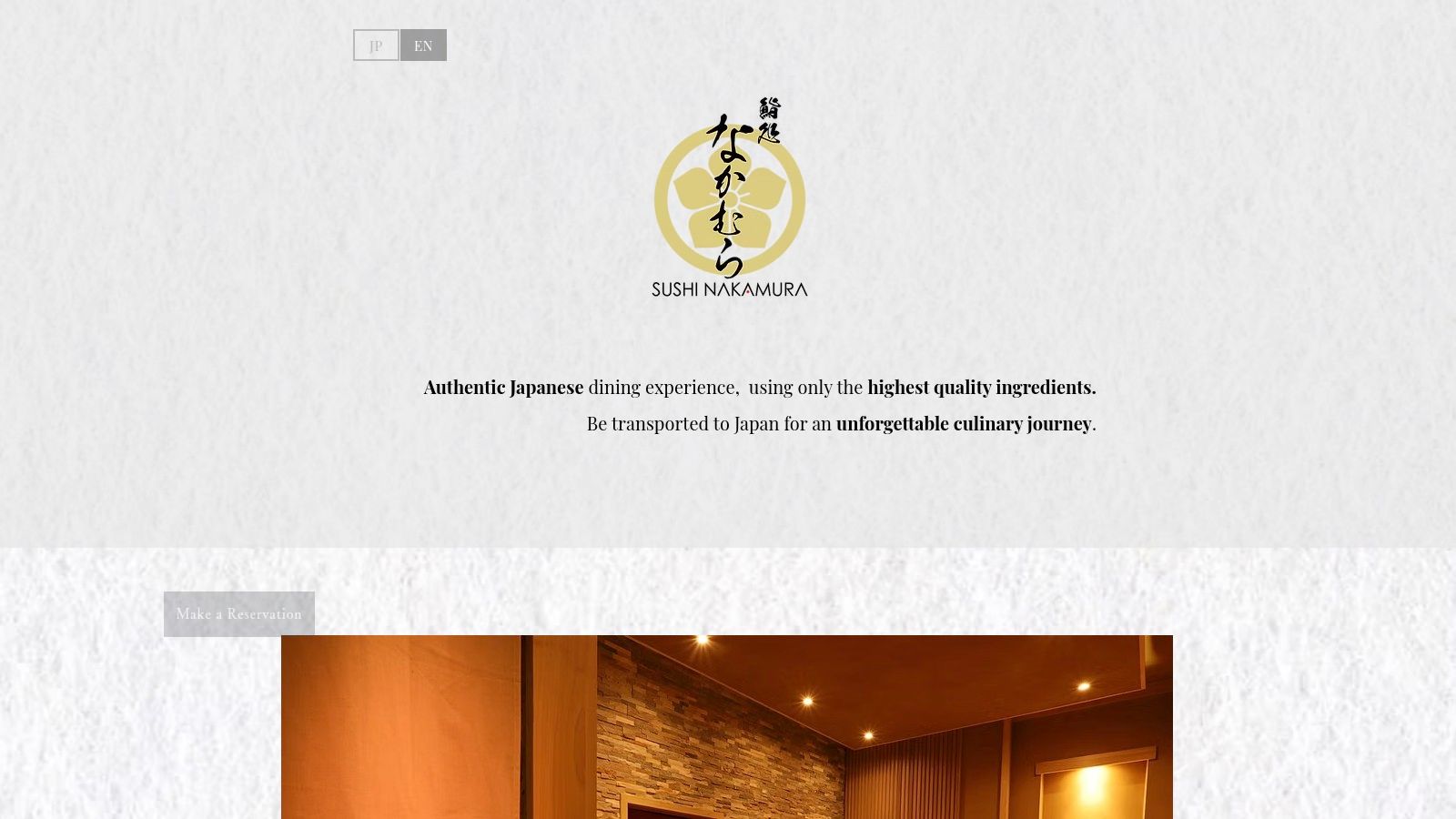 An artfully presented piece of nigiri sushi on a dark plate, with a chef's hands in the background.