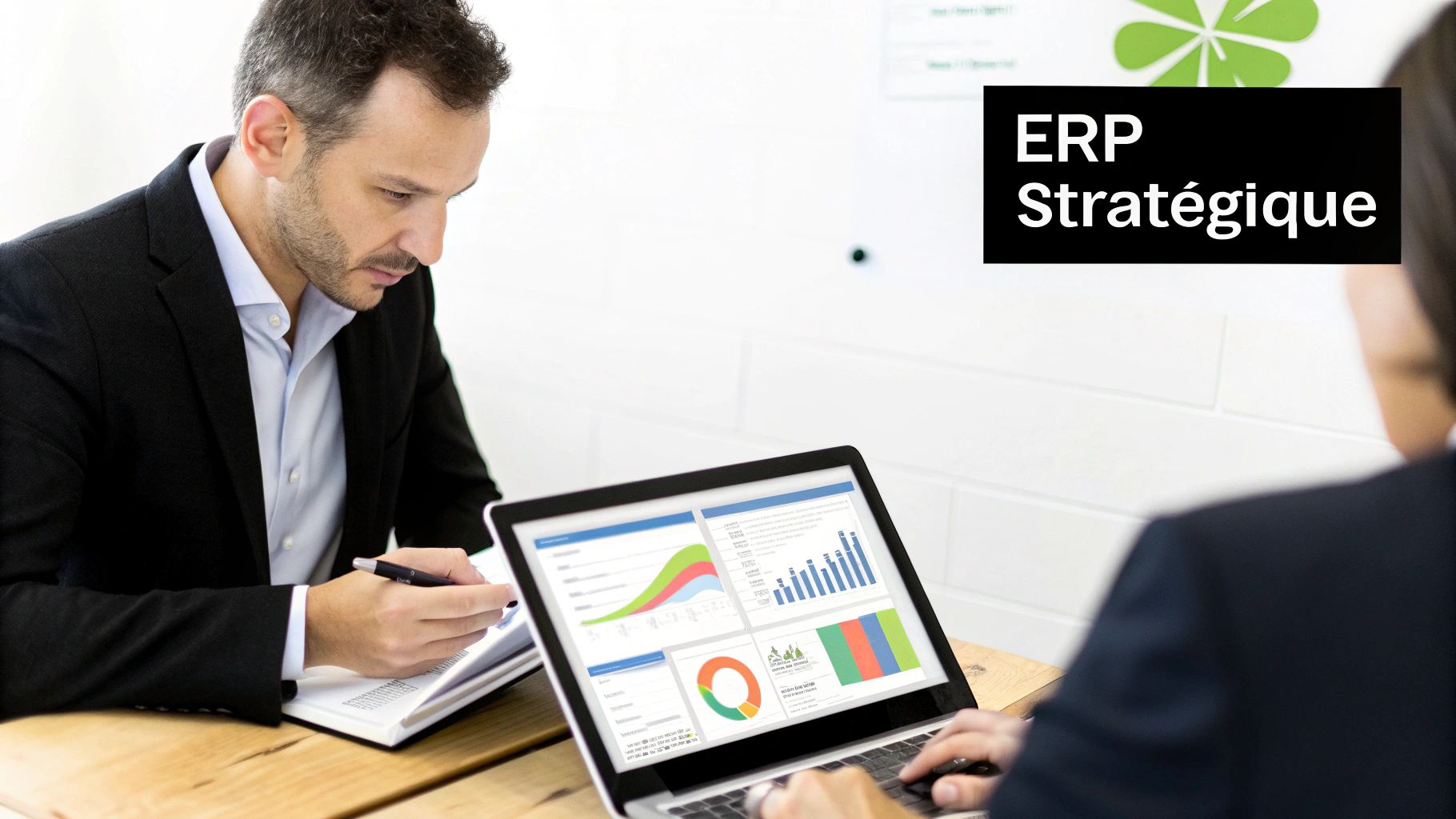 Deux professionnels analysant des données sur un ordinateur portable et prenant des notes, avec un panneau "ERP Stratégique" en arrière-plan.