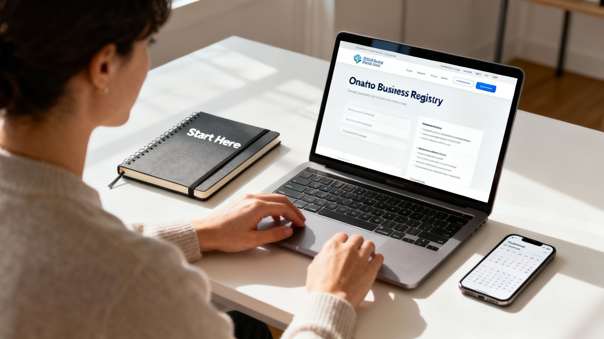 A person working on a laptop with business registration documents nearby.