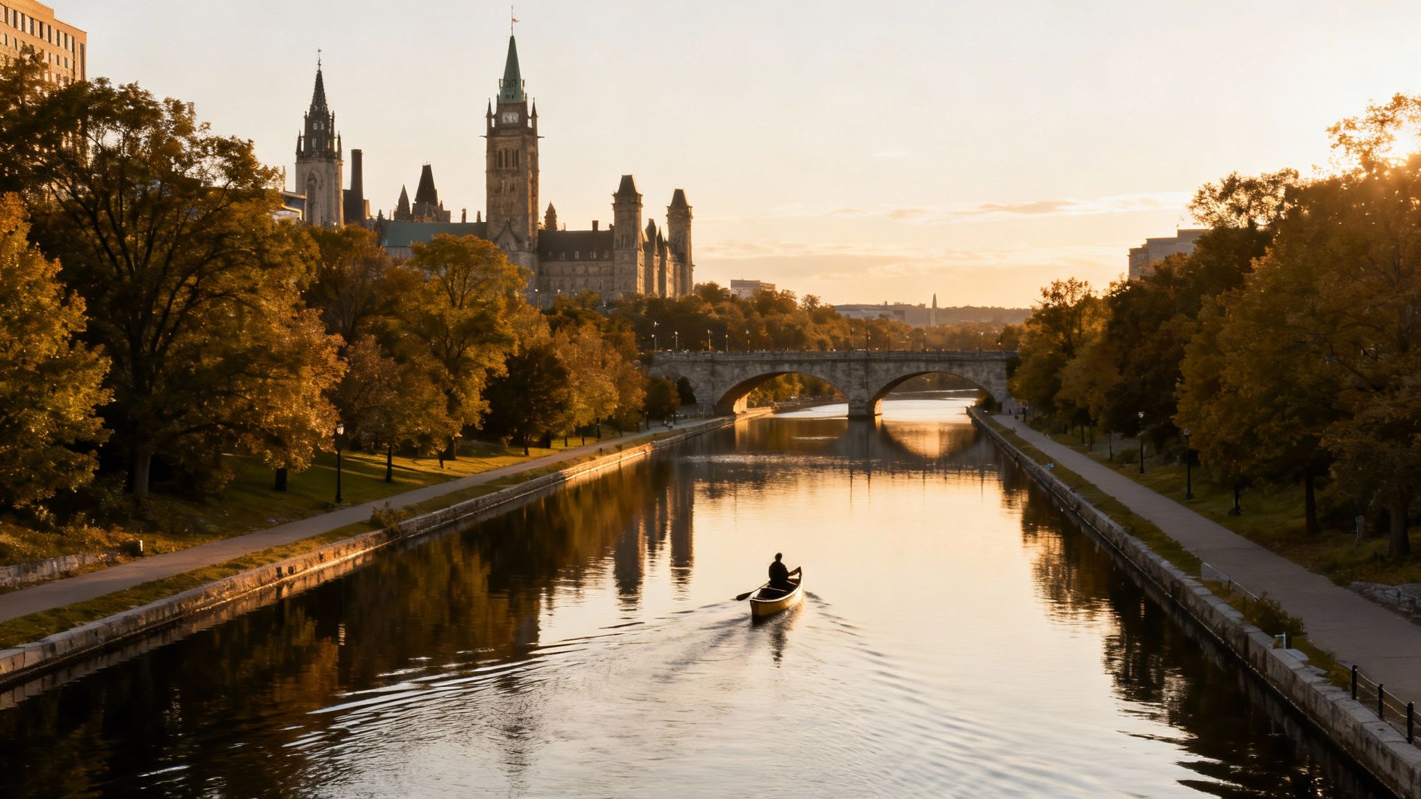 A lone canoeist paddles on the historic Rideau Canal at sunset, with autumn trees and Parliament Hill visible.