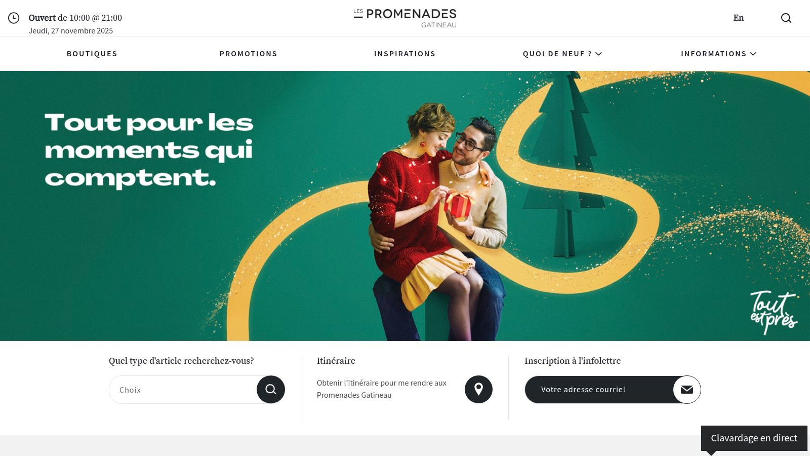 A happy couple enjoys their Christmas shopping experience at a brightly lit mall, carrying bags from various stores.