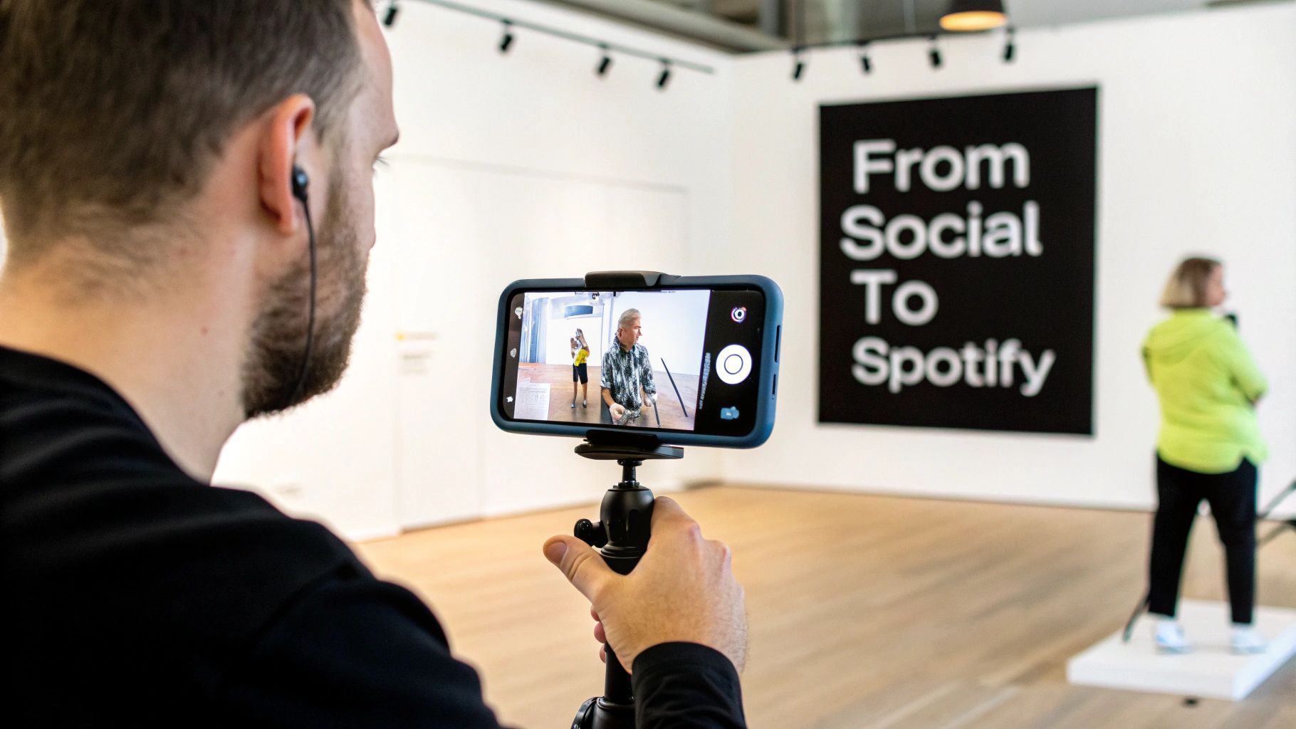 A man films a live session on a smartphone with a 'From Social To Spotify' banner in the background.
