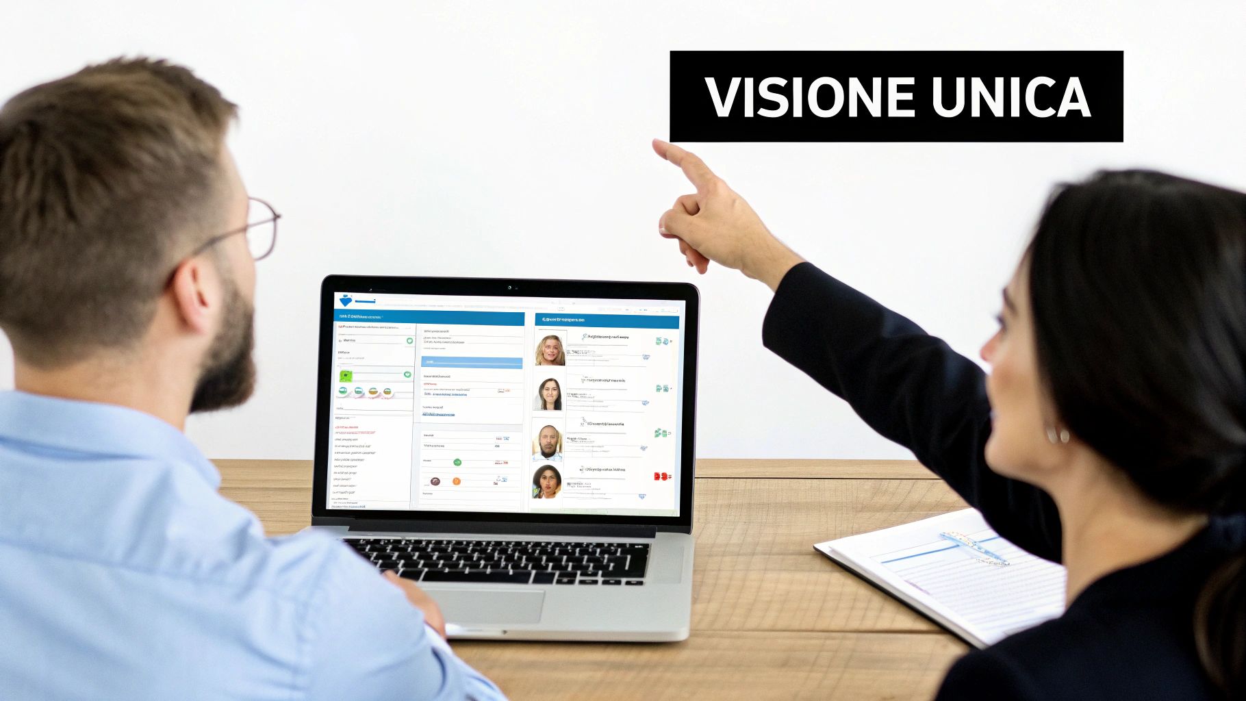 Due persone osservano uno schermo laptop che mostra un'interfaccia software con profili utente, mentre una mano indica la scritta 'VISIONE UNICA' su sfondo bianco.