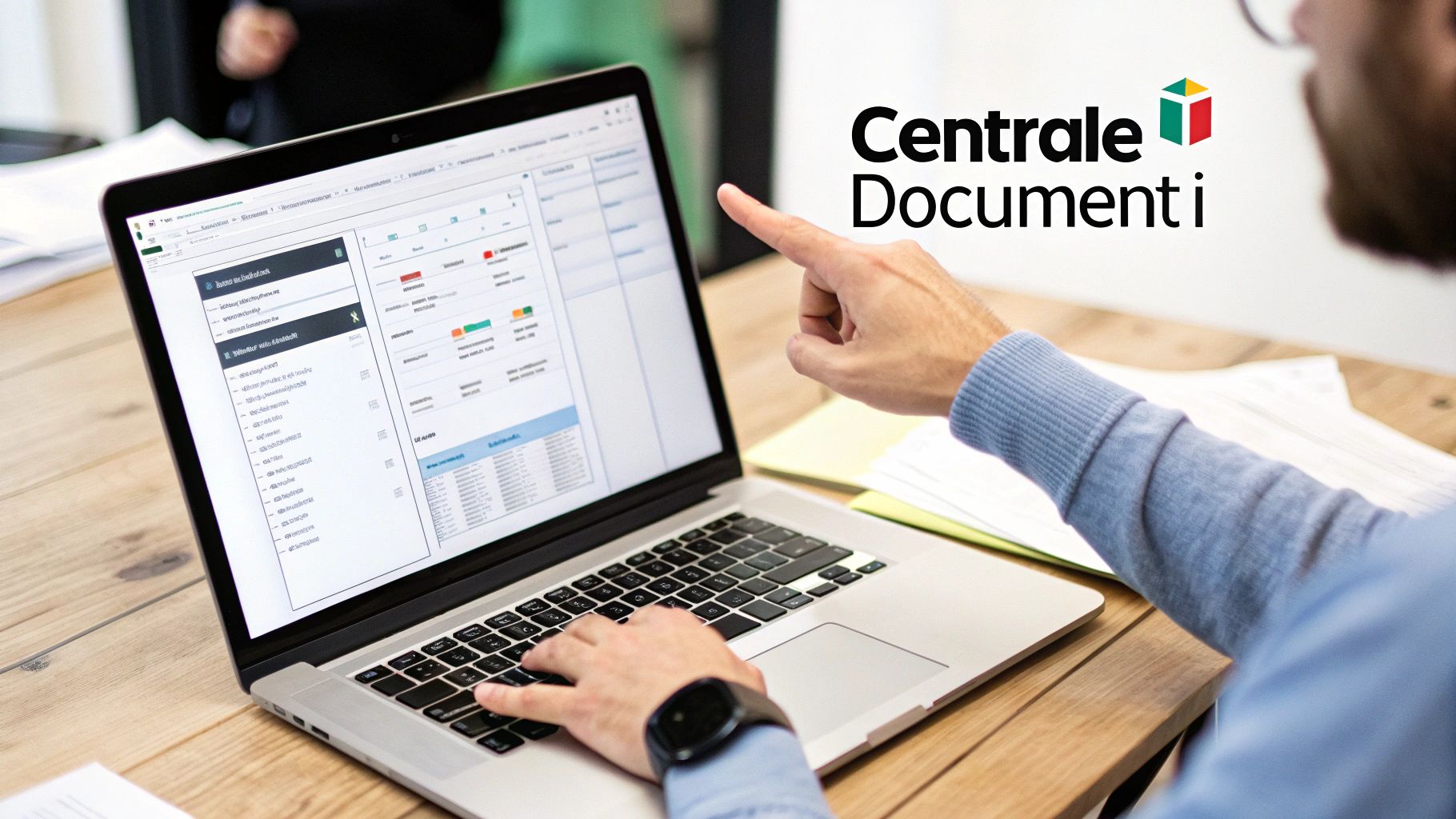 Uomo lavora al laptop con un'applicazione di gestione documenti, indicando lo schermo, in un ambiente d'ufficio.
