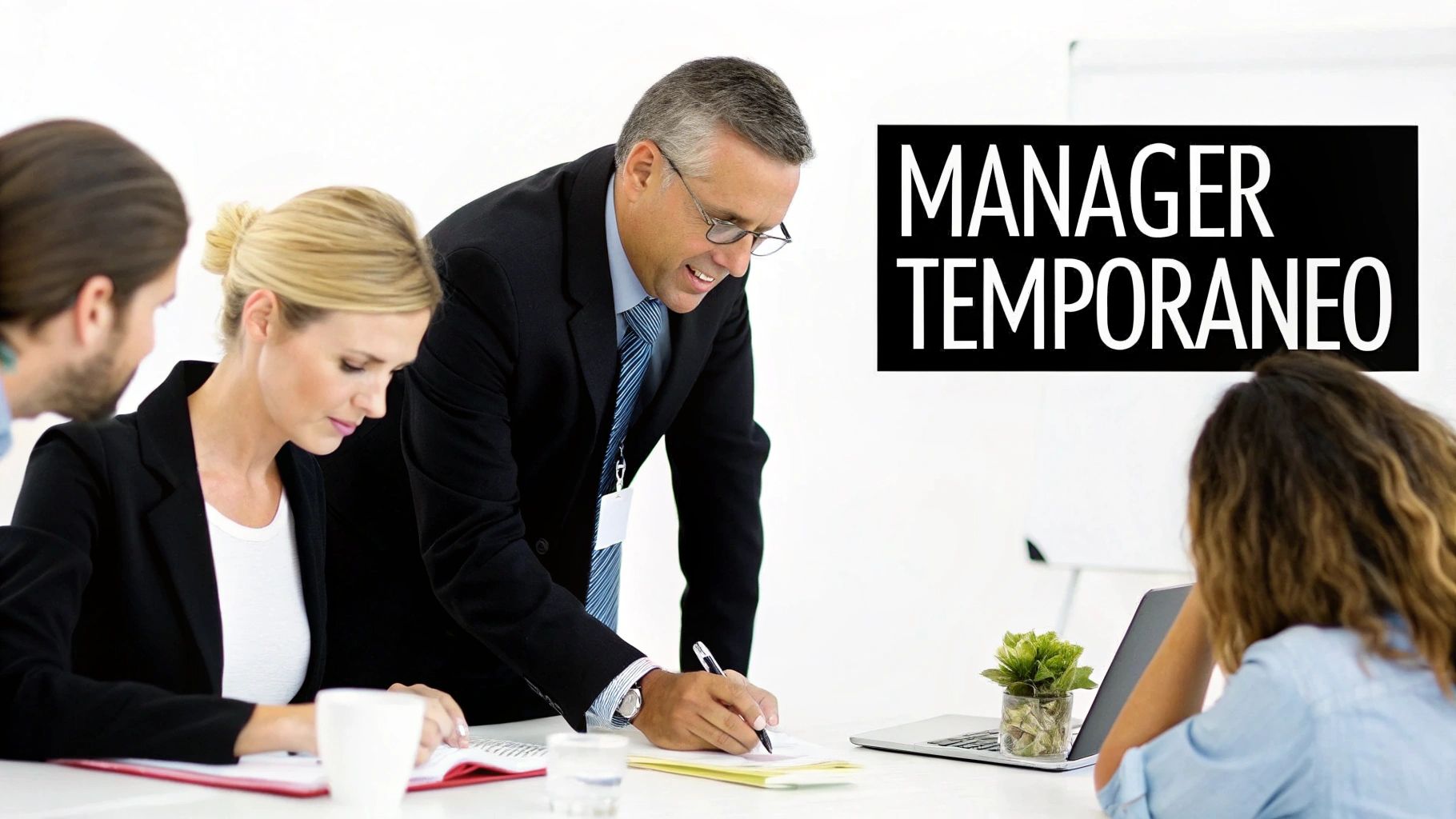 Professionisti in riunione d'ufficio, un manager scrive e altri collaborano, enfatizzando il ruolo del manager temporaneo.