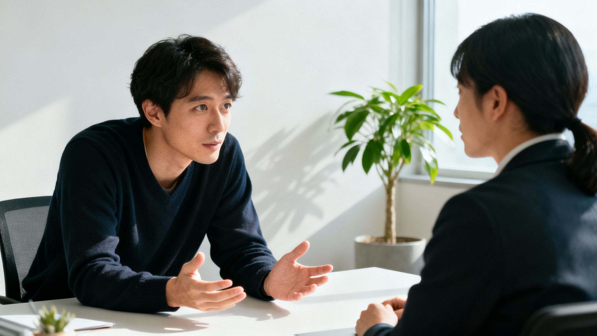 Two colleagues engaged in a focused discussion at a modern office desk during a meeting.