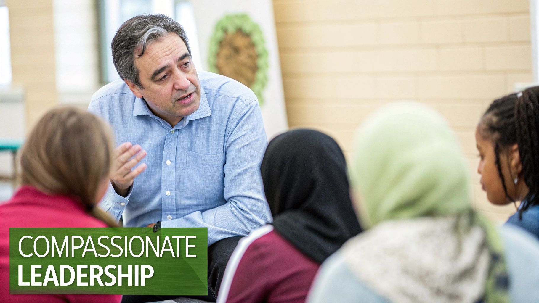A diverse group of students attentively listens to a male leader discussing compassionate leadership.