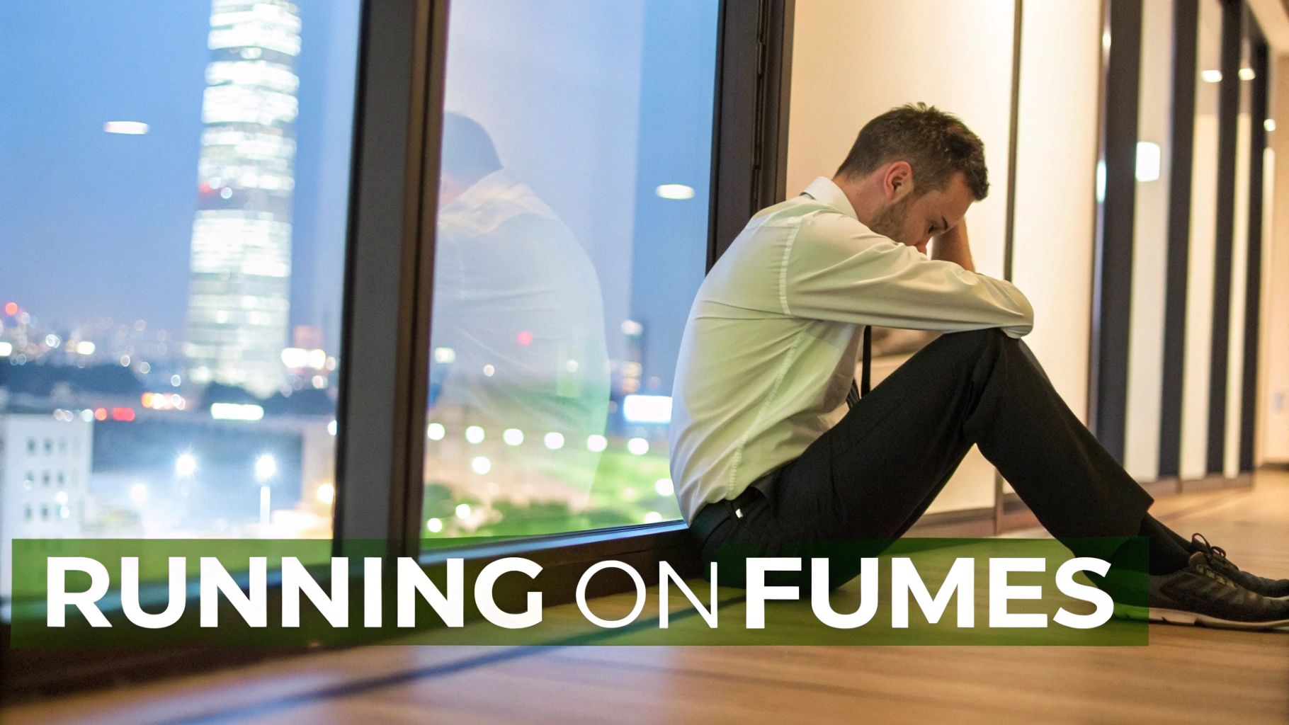 A distressed businessman in a shirt and tie sits on the floor by a city window at night. A distressed businessman in a shirt and tie sits on the floor by a city window at night.