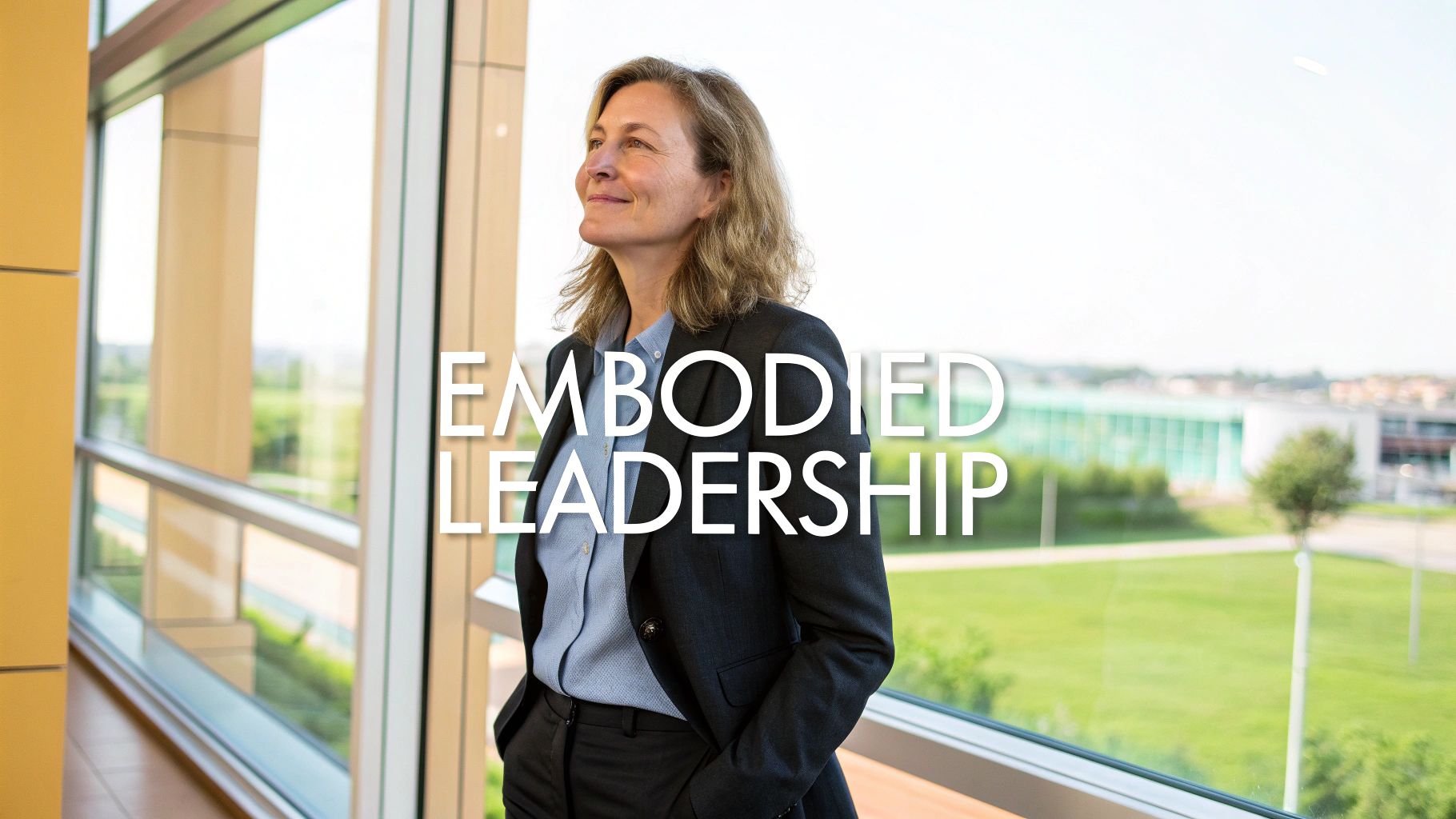 A confident woman in a suit stands by a window, looking up with 'Embodied Leadership' text.
