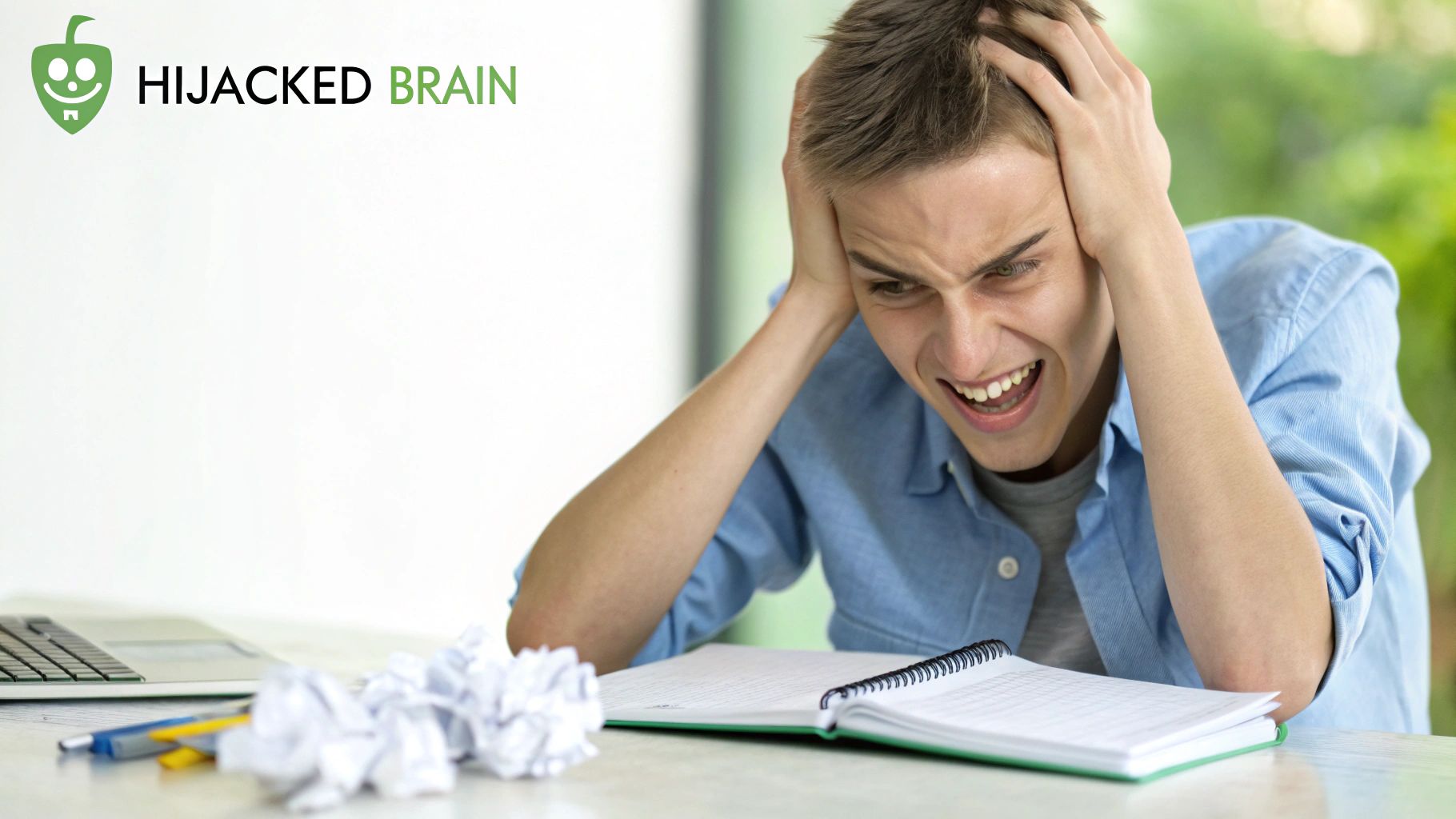 A young man looking overwhelmed and stressed, holding his head while studying at a desk. A young man looking overwhelmed and stressed, holding his head while studying at a desk.